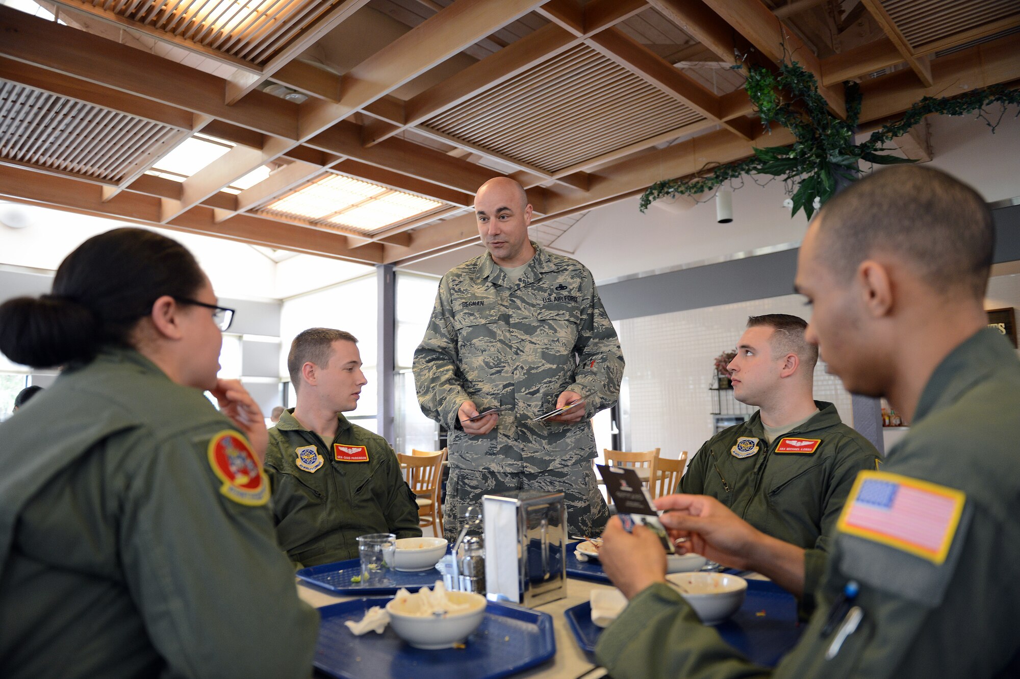 Master Sgt. Erik Degnan, 627th Force Support Squadron first sergeant, hands out gift cards to Airmen at the Olympic Dining Facility, April 9, 2014, at Joint Base Lewis-McChord, Wash. Team McChord first sergeants passed out gift cards to young Airmen as random acts of kindness sponsored by Operation Warmheart. (U.S. Air Force photo by Airman First Class Jacob Jimenez) 