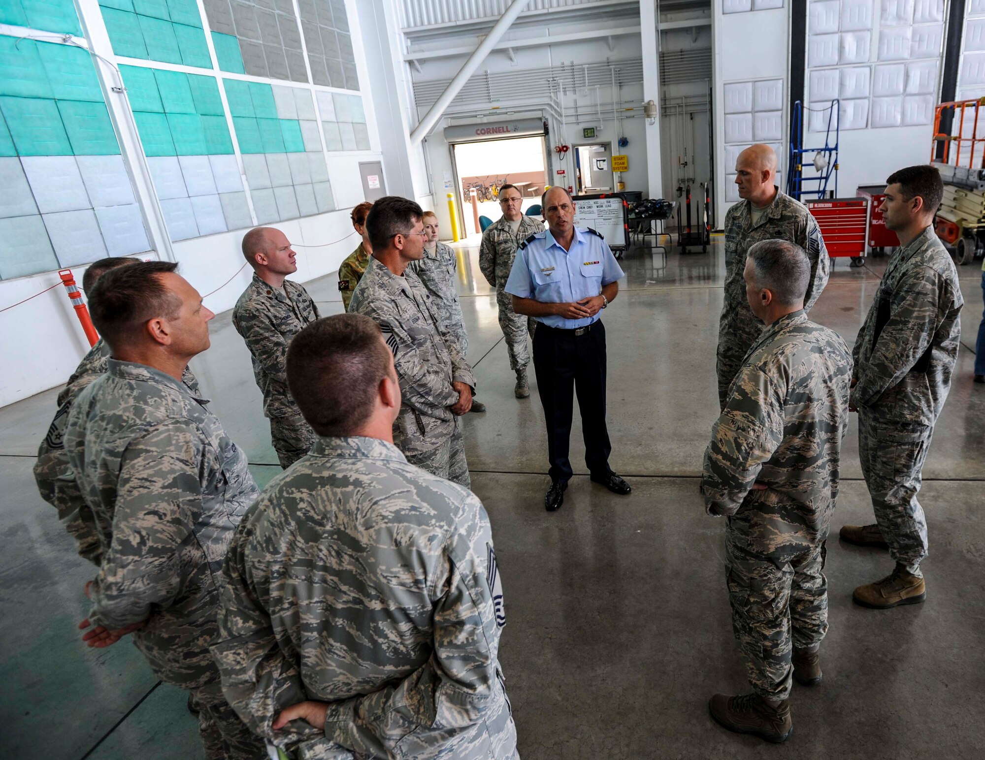 Commodore Peter Yates, Royal Australian Air Force general logistics director, asks questions about corrosion control and maintenance procedures during a briefing with 15th Maintenance Group leadership in Hangar 21 on Joint Base Pearl Harbor-Hickam, Hawaii, April 7, 2014. Yates is visiting JBPHH to conduct tactical-level discussions on how the RAAF and USAF can expand their interoperability in order to deliver seamless integration of forces.  (U.S. Air Force photo/Tech. Sgt. Terri Paden)