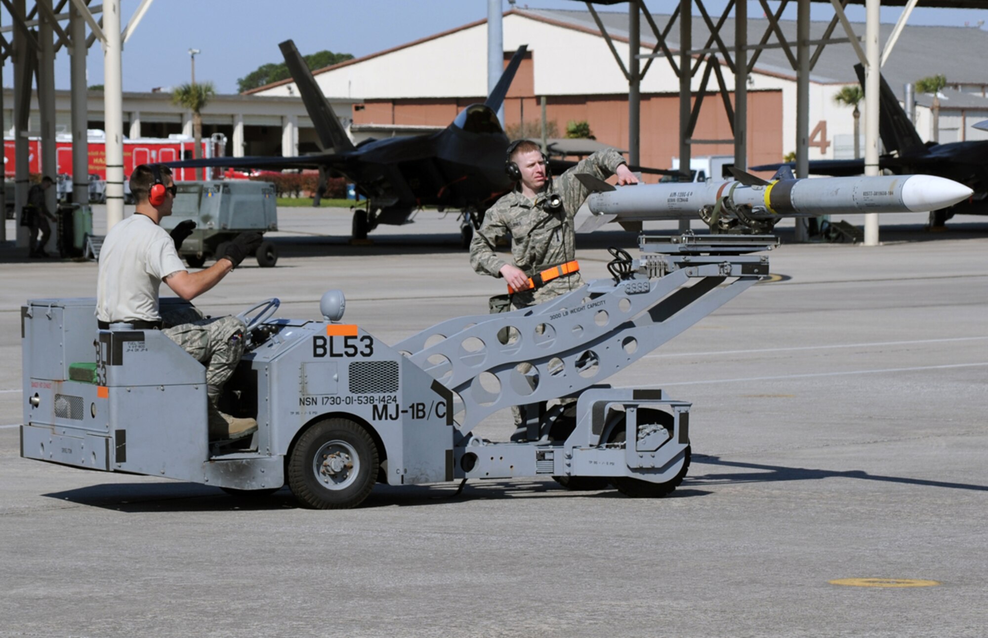 Senior Airman Andrew Messinger, left, and Air Force Staff Sgt. Michael Jones transport a missile across the flight line at Tyndall Air Force Base, Fla., March 26, 2014. Messinger is a member of the 3rd Aircraft Maintenance Squadron and Jones is a member of the 90th Aircraft Maintenance Unit out of Joint Base Elmendorf-Richardson, Alaska. (U.S. Air Force photo/Master Sgt. Scott Wilcox)