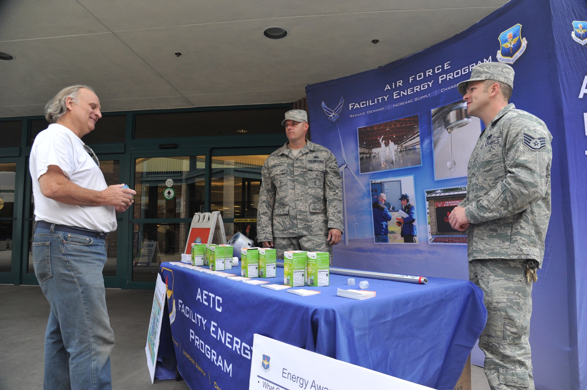 Master Sgt. Adam Kelley, 56th Civil Engineer Squadron base energy manager, and Staff Sgt. Paul Shepherd, 56th CES base utility manager, explain energy conservation techniques to Robert Wimp at the energy conservation month booth at Luke Air Force Base, Ariz., April 9, 2014. (U.S. Air Force photo by Senior Airman Jason Colbert) 
