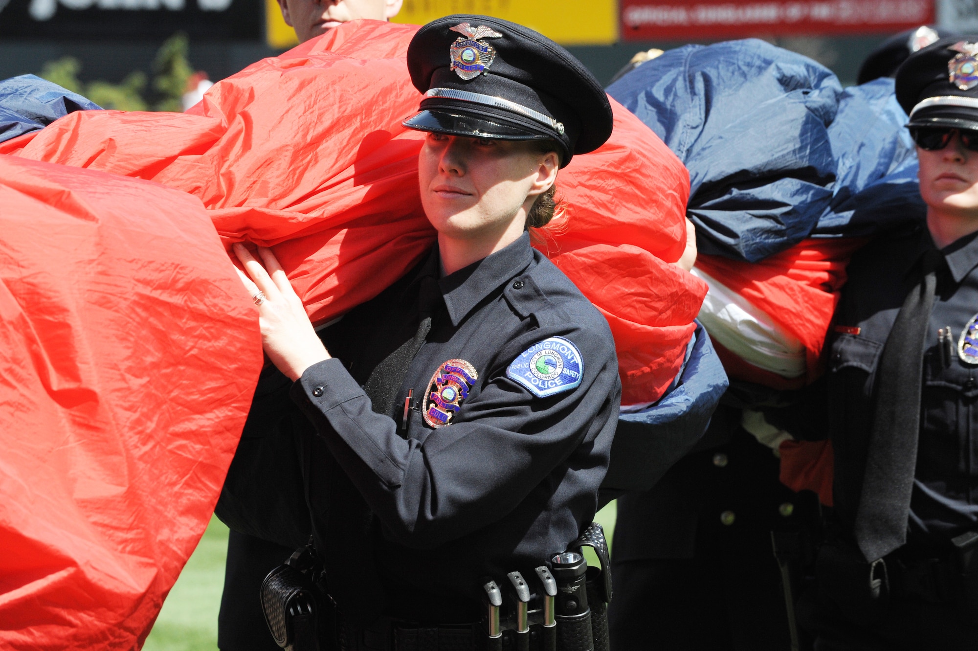 Colorado law enforcement officers carry the American Flag onto the field to be displayed during the Colorado Rockies Opening Day ceremony April 4, 2014, at Coors Field, Denver. Service members from all U.S. military branches stood in formations as local law enforcement and service members unfurled the American Flag during the opening day ceremonies (U.S. Air Force photo by Airman Emily E. Amyotte/Released))