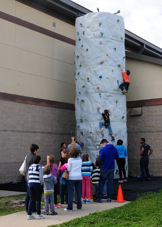 Beale youth climb a rock wall during the Children’s Spring Carnival at the Youth Center on Beale Air Force Base, Calif., April 4, 2014. The event featured a bounce house, putt-putt golf, mini games, face painting, food, treats and prizes. (U.S. Air Force photo by Senior Airman Allen Pollard/Released)