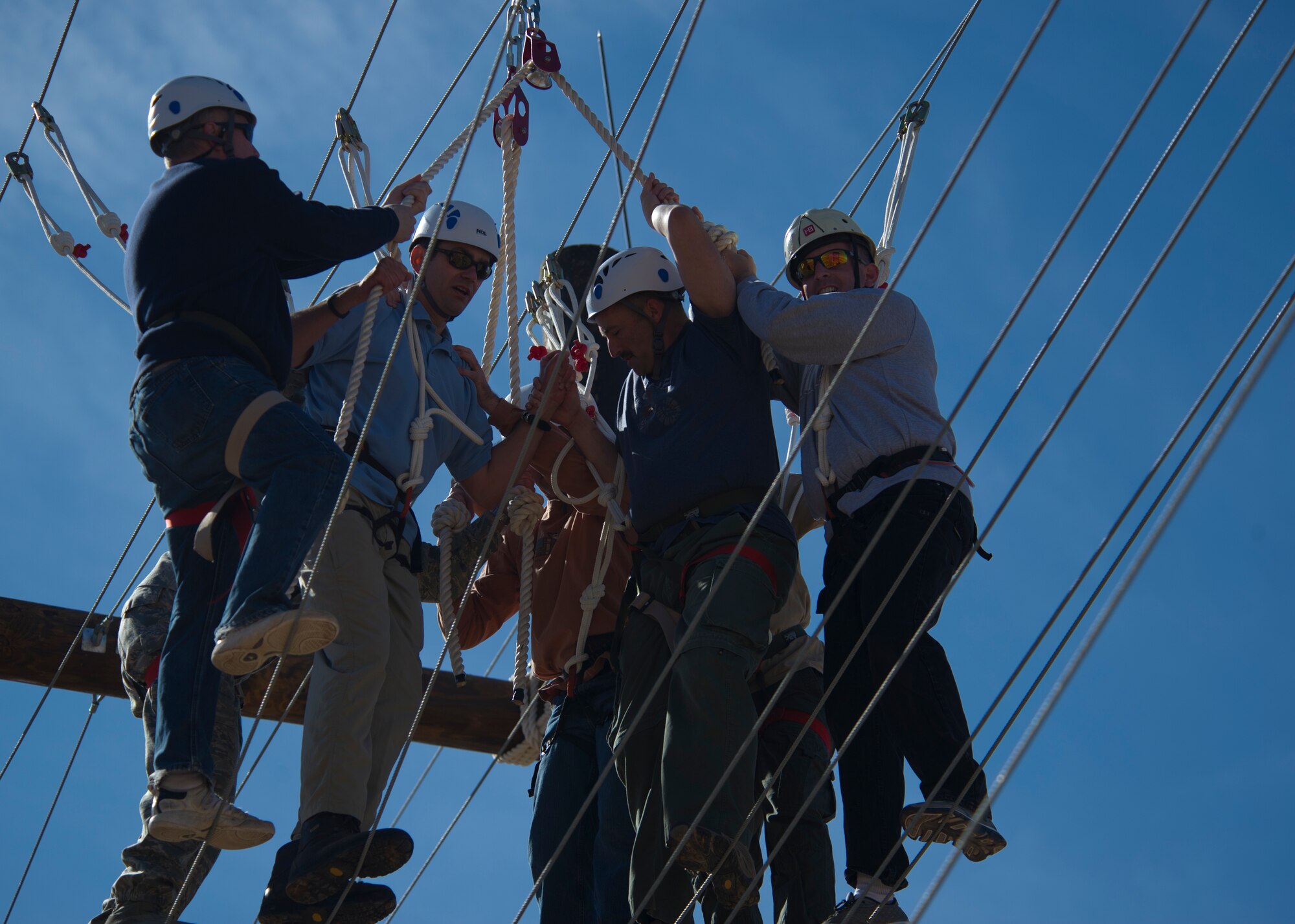 Members of Team Holloman leadership navigate a Ropes Course challenge at Holloman Air Force Base, N.M., March 29. Members of Team Holloman leadership and their families were introduced to the new Ropes Course as a team building exercise and to showcase all of the possible activities available on the course. (U.S. Air Force photo by Airman 1st Class Aaron Montoya / Released)