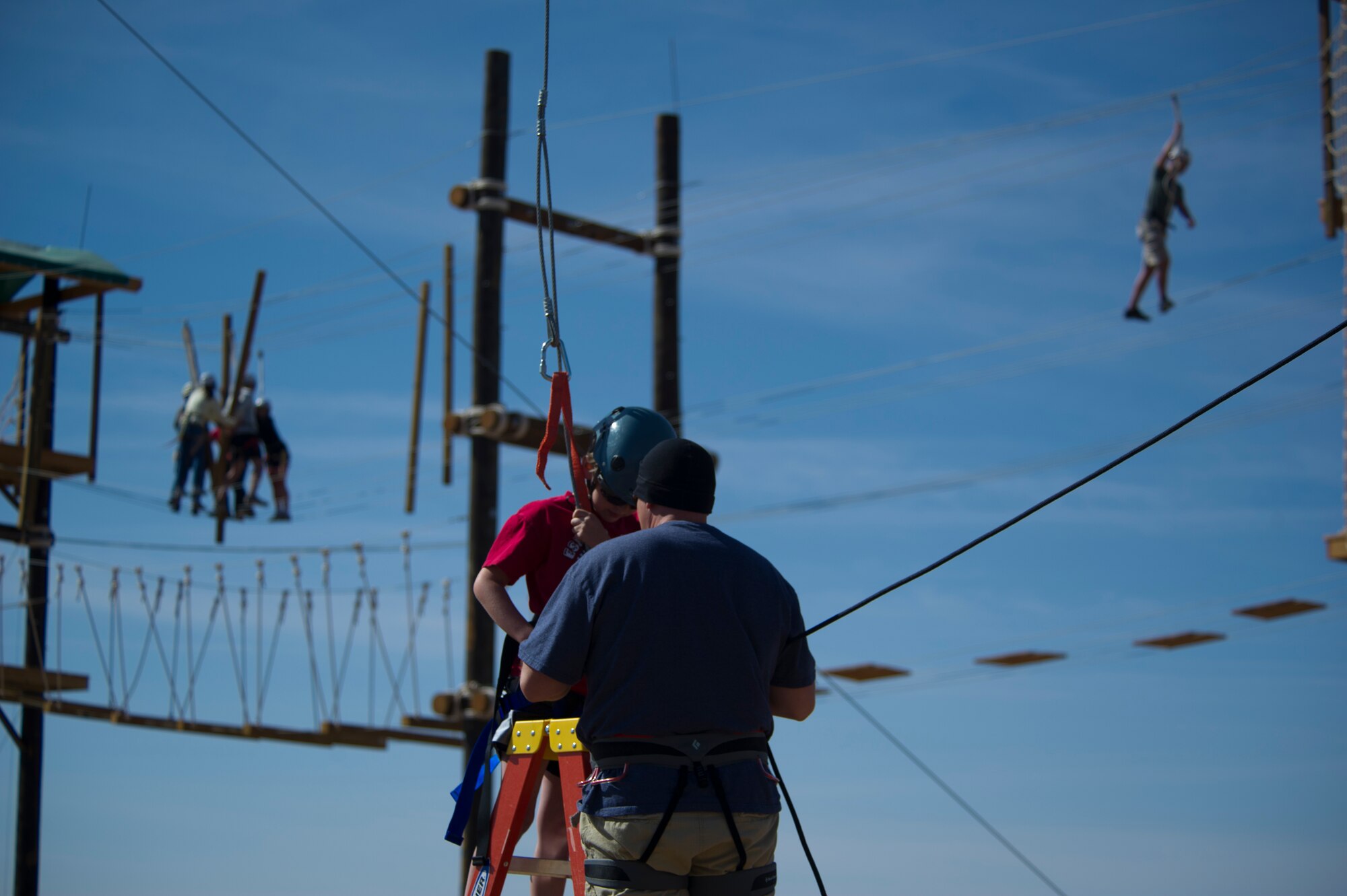 A Team Holloman dependent straps on a harness before swinging on a rope swing at Holloman Air Force Base, N.M., March 29. Members of Team Holloman leadership and their families were introduced to the new Ropes Course as a team building exercise and to showcase all of the possible activities available on the course. (U.S. Air Force photo by Airman 1st Class Aaron Montoya / Released)
