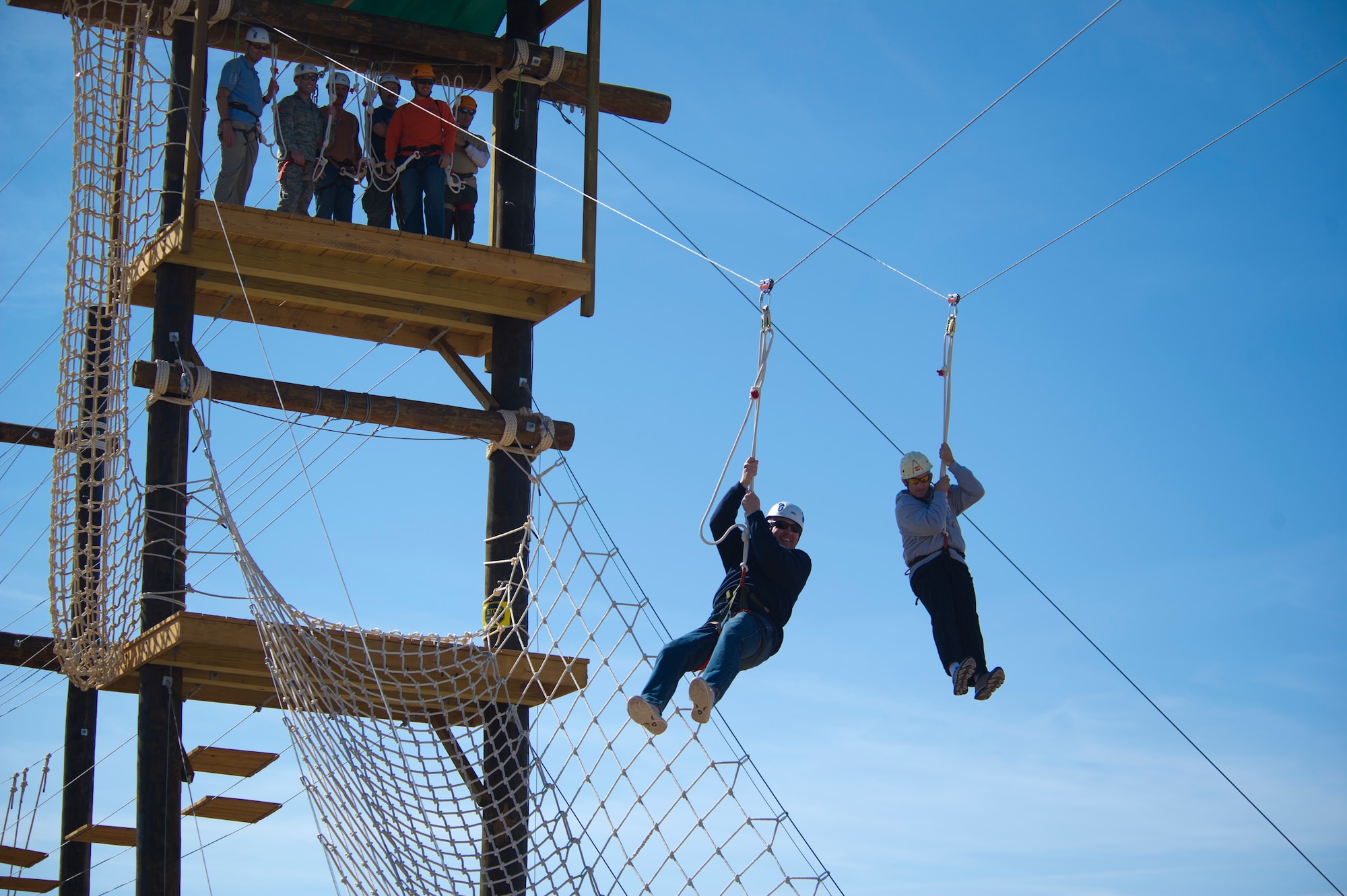 Members of Team Holloman leadership zip line after completing a Ropes Course challenge at Holloman Air Force Base, N.M., March 29. Members of Team Holloman leadership and their families were introduced to the new Ropes Course as a team building exercise and to showcase all of the possible activities available on the course. (U.S. Air Force photo by Airman 1st Class Aaron Montoya / Released)