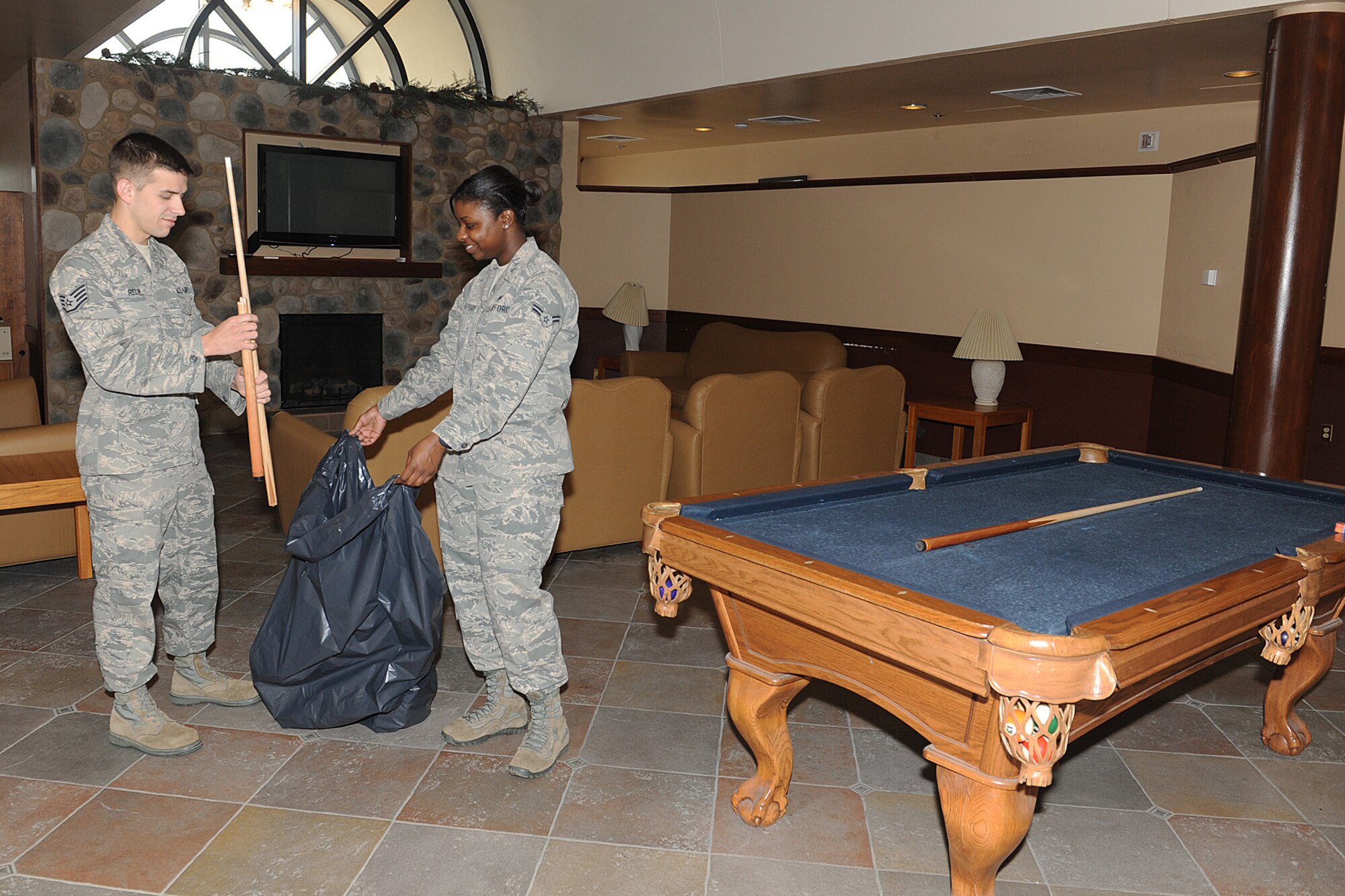 Staff Sgt. Jason Relik and Airman 1st Class Sierra Strafford throw away a broken pook stick at the Belleville Dormitory April 2. Relik is an Airman dormitory leader, and Strafford is on bay-orderly duty and is required to clean the common areas of the dorms. (U.S. Air Force photo/ Staff Sgt. Maria Bowman)