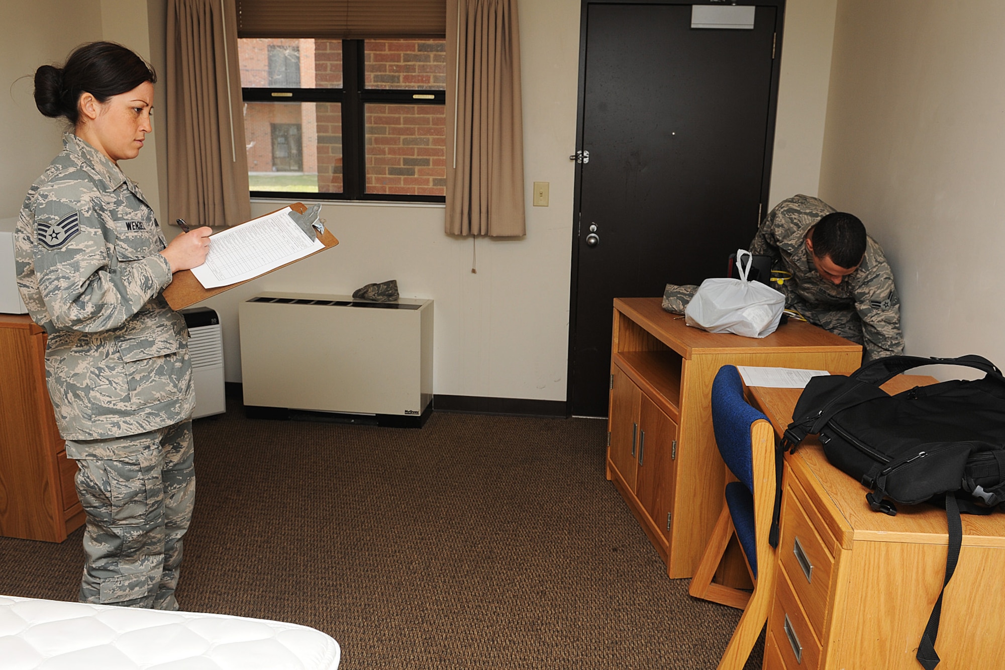 Staff Sgt. Erika Wenzel goes through a move-out checklist with Airman 1st Class Joseph French, 375th Operations Support Squadron. Residents must pass inspections before moving out. (U.S. Air Force photo/ Staff Sgt. Maria Bowman)