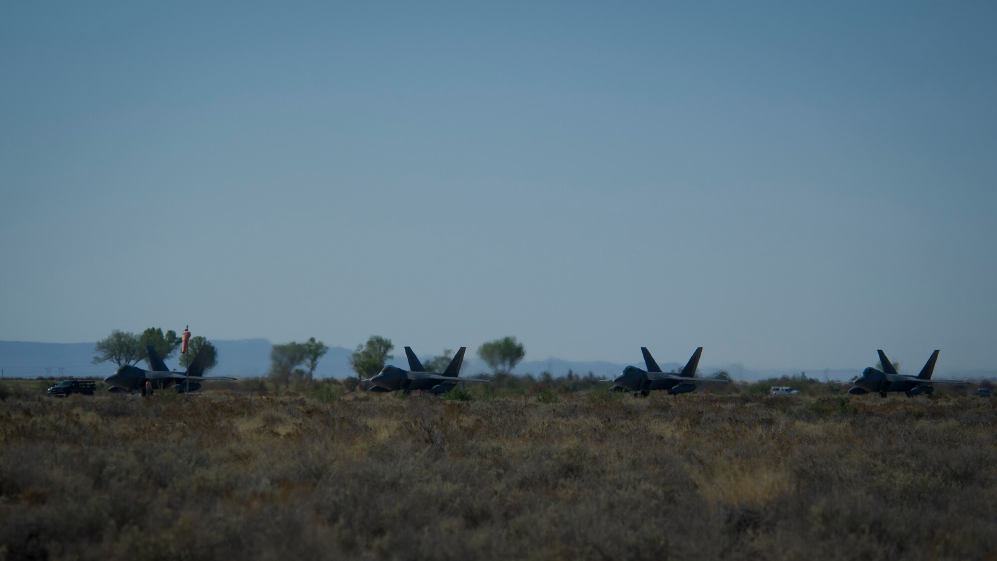 The last four F-22 Raptors with the 7th Fighter Squadron prepare to depart for Tyndall Air Force Base, Fla., at Holloman Air Force Base, N.M., April 8. Holloman bids farewell to the F-22 Raptors as the 7th Fighter Squadron transitions its mission to Tyndall to continue training for air superiority. (U.S. Air Force photo by Airman 1st Class Aaron Montoya / Released)