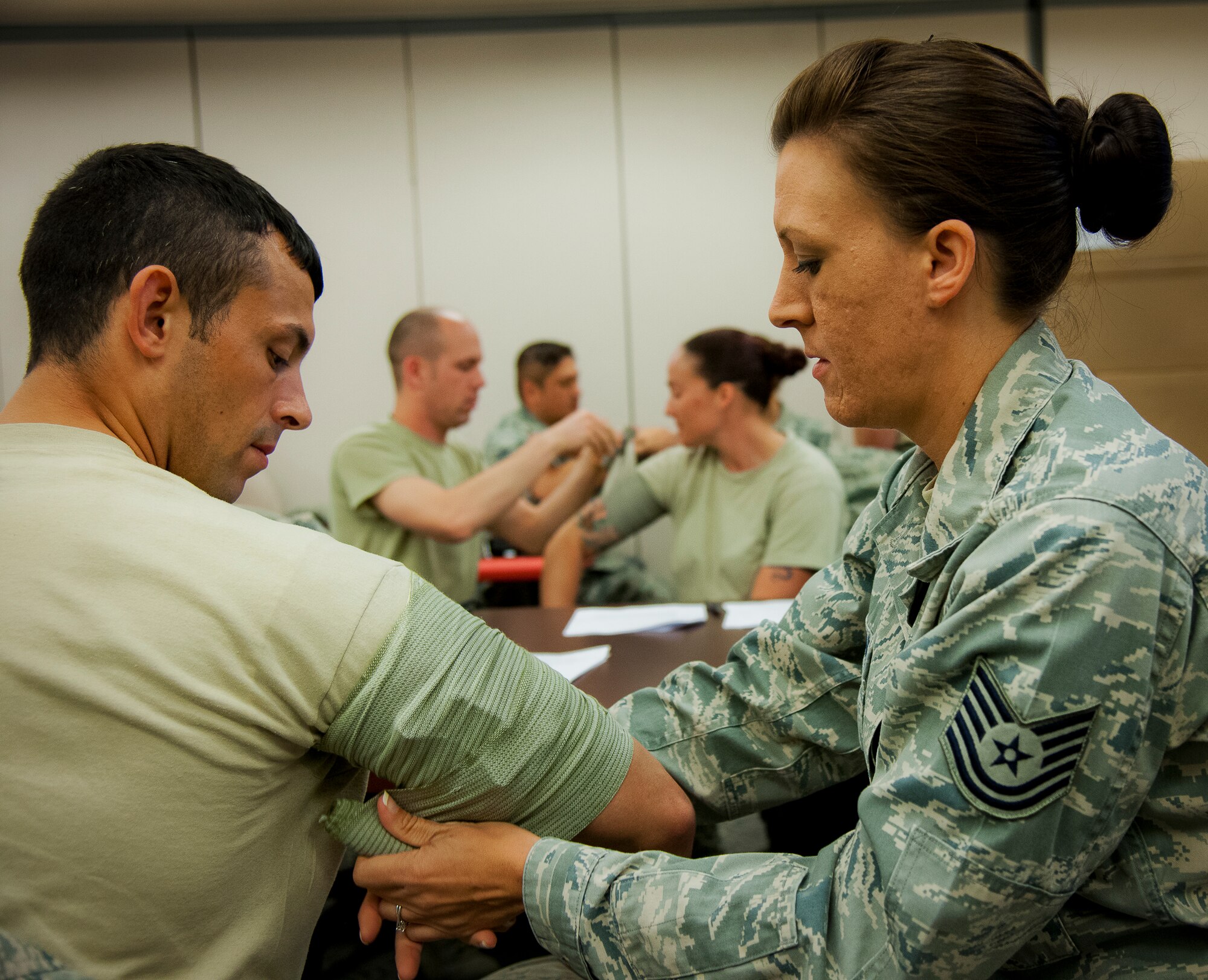 Tech. Sgt. Kelsey Woodhouse, from the 919th Special Operations Logistics Readiness Squadron, applies a combat bandage to Staff Sgt. Ryan Santini during a Self-Aid and Buddy Care instructor course at Duke Field April 4.  The course was offered during the 919th’s annual four-day Super UTA that focuses heavily on ancillary training.  (U.S. Air Force photo/Tech. Sgt. Samuel King Jr.)
