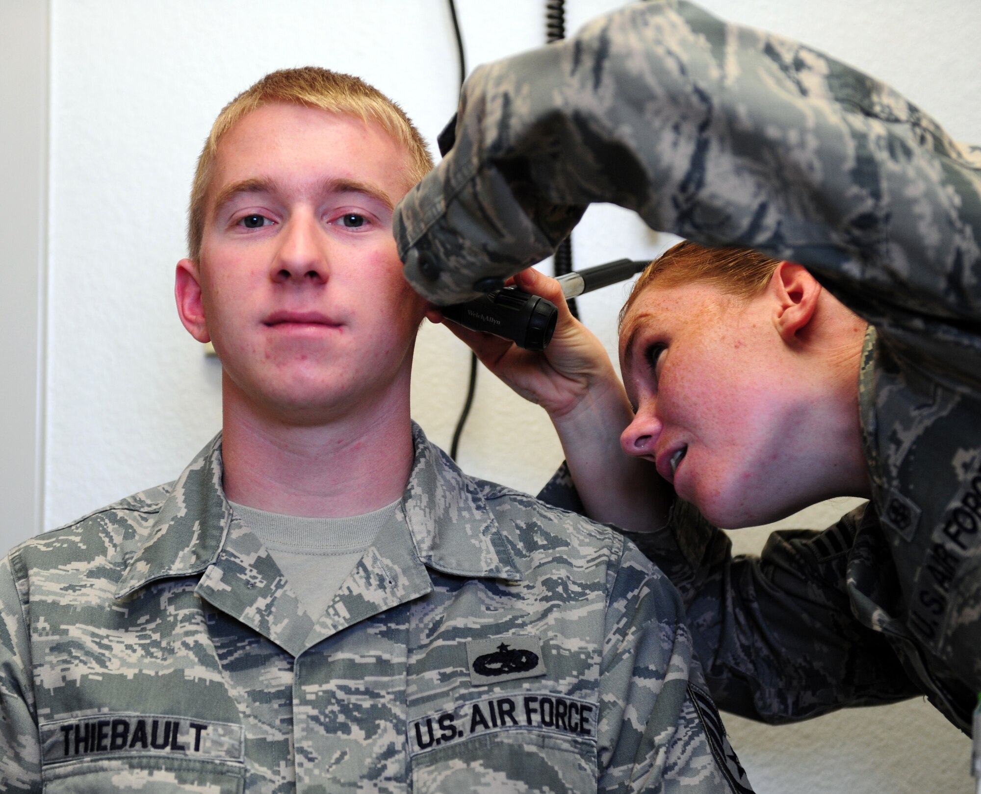 U.S. Air Force Staff Sgt. James Thiebault, left, 7th Aircraft Maintenance Squadron avionics specialist, receives an ear exam from Senior Airman Christina Newman, 7th Aerospace Medicine Squadron hearing conservation program manager, before receiving his annual hearing test April 3, 2014, at Dyess Air Force Base, Texas. Although it consists of many different elements, the overall goal of public health is to protect the base populous and keep Airmen healthy and fit to fight. (U.S. Air Force photo by Senior Airman Kia Atkins/Released)