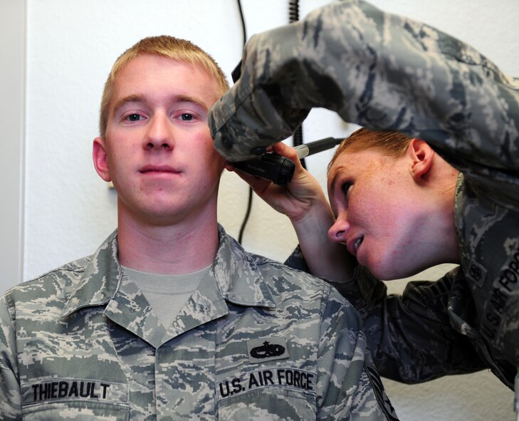 U.S. Air Force Staff Sgt. James Thiebault, left, 7th Aircraft Maintenance Squadron avionics specialist, receives an ear exam from Senior Airman Christina Newman, 7th Aerospace Medicine Squadron hearing conservation program manager, before receiving his annual hearing test April 3, 2014, at Dyess Air Force Base, Texas. Although it consists of many different elements, the overall goal of public health is to protect the base populous and keep Airmen healthy and fit to fight. (U.S. Air Force photo by Senior Airman Kia Atkins/Released)