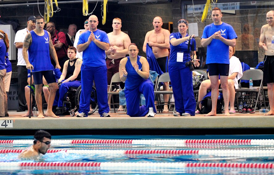 Air Force wounded warrior participants and staff members cheer and clap for (Ret.) Staff Sgt. Daniel Crane during a swimming race at the Air Force Wounded Warrior Team Trials at the at the University of Nevada, Las Vegas, Natatorium swimming pool April 7, 2014. Crane won first place in the 50-meter swimming freestyle for upper body impairment competition. (U.S. Air Force photo by Senior Master Sgt. Cecilio Ricardo)