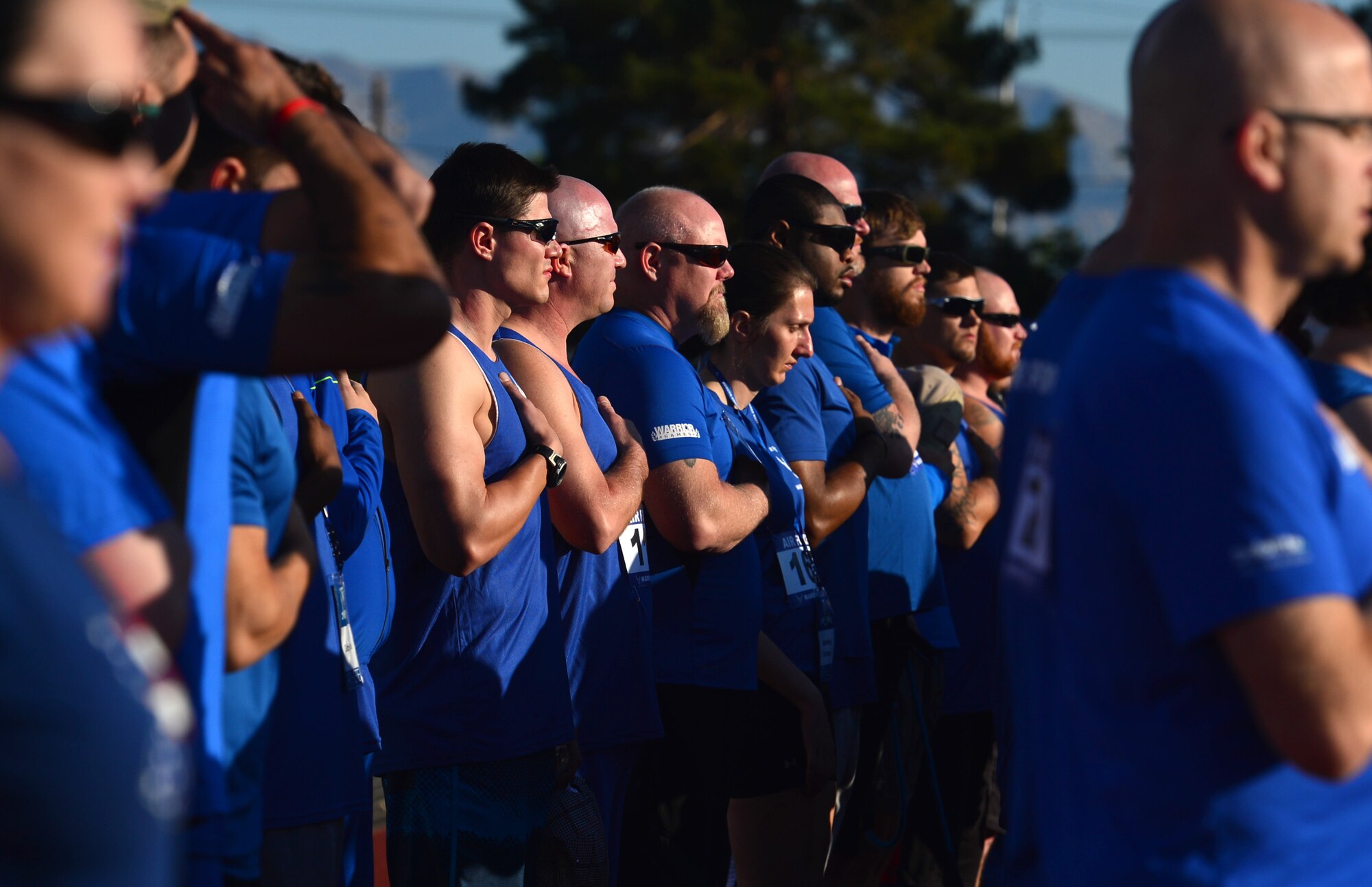 Wounded Warriors stand and pay their respects to the U.S. flag during the Air Force Team Trials, April 8, 2014 at Rancho High School, Las Vegas.  During the weeklong event wounded warriors participated in swimming, basketball, volleyball, track and field events, cycling, archery and shooting competitions. (U.S. Air Force photo by Staff Sgt. Nadine Barclay)