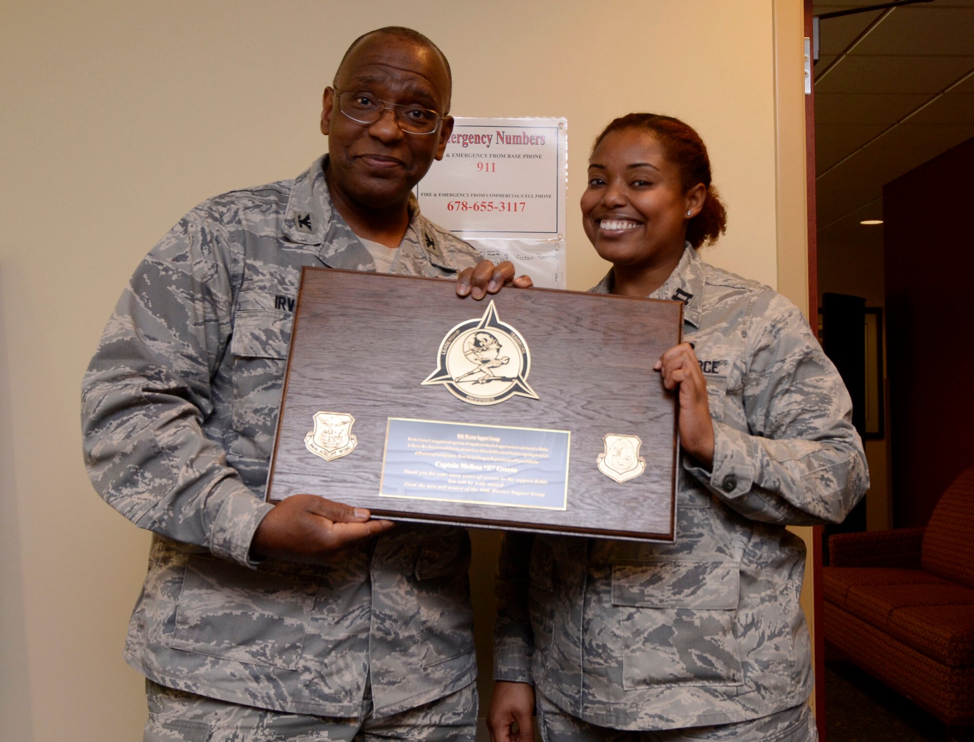 Col. Marshall Irvin, 94th Mission Support Group commander, presents Capt. Melissa Greene, former 94th AW executive officer with a token of appreciation as she departs Dobbins Air Reserve Base March 13, and begans the next stage of her Air Force career. Green served as the 94th Mission Support Group executive officer 2009-2011. (U.S. Air Force photo/Don Peek)