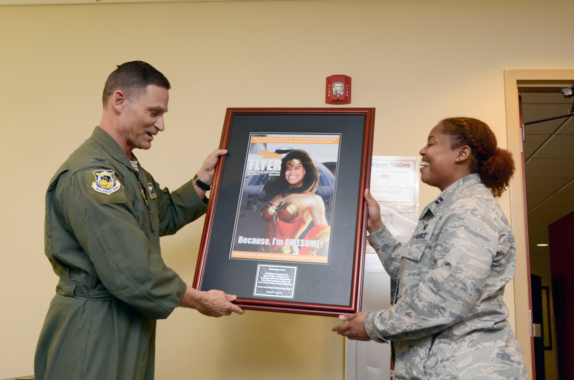 Col. Brett Clark, 94th Airlift Wing commander, presents Capt. Melissa Greene, former 94th AW executive officer with a gift as she departs Dobbins Air Reserve Base March 13, and begans the next stage of her Air Force career. Green served as the 94th Mission Support Group executive officer 2009-2011, and as the 94th Force Support Squadron Personnel Systems and Readiness officer-in-charge. (U.S. Air Force photo/Don Peek)