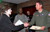 Col. Courtney Arnold, 302nd Airlift Wing commander, hands a certificate of appreciation to Cheryl Parrish at the conclusion of Employer Appreciation Day, April 4, 2014, as Chief Master Sgt. Otis Jones, 302nd Airlift Wing command chief looks on. Parrish is the vice president of programs for Alzheimer’s Association of Colorado. (U.S. Air Force photo/Ann Skarban) 