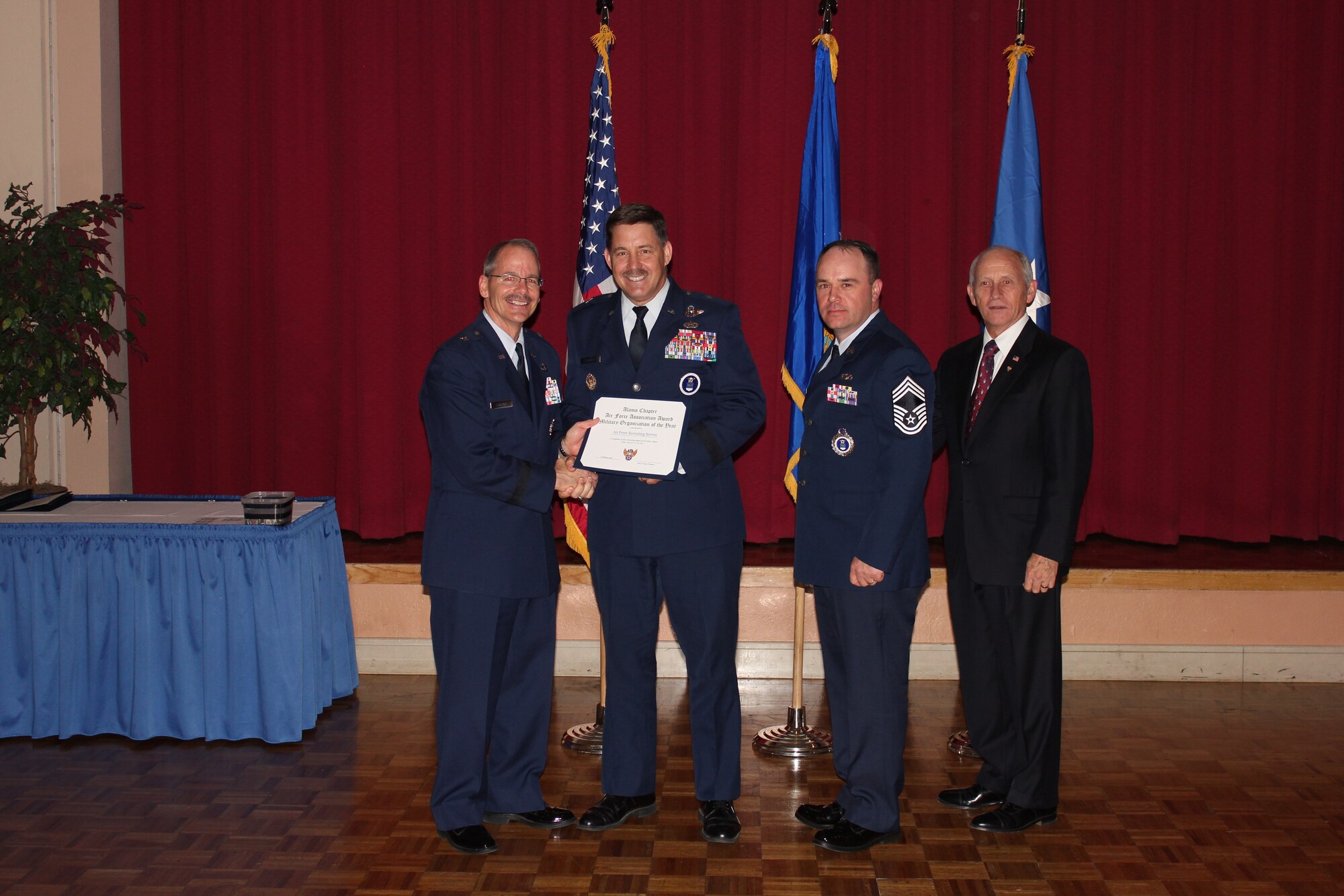 Brig. Gen. Robert D. LaBrutta, 502nd Air Base Wing commander (left), and Al Swaim, Air Force Association Alamo Chapter president (right), present the Military Organization of the Year Award to Brig. Gen. John P. Horner, Air Force Recruiting Service commander, and Chief Master Sgt. Wade A. Trahan, AFRS Information Systems Division superintendent, during the AFA Alamo Chapter's annual awards banquet at Joint Base San Antonio-Lackland, Texas, March 25. (U.S. Air Force photo)