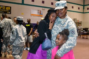 U.S. Army Sgt. 1st Class Tangela Brown, 53rd Transportation Battalion, 7th Transportation Brigade (Expeditionary), embraces her children during a redeployment ceremony at Fort Eustis, Va., April 7, 2014. Approximately 50 Soldiers from the 53rd Trans. Bn. supported Operation Enduring Freedom in Kuwait as a headquarters and headquarters detachment. (U.S. Army photo by Sgt. Eveangeline Ellis/Released)