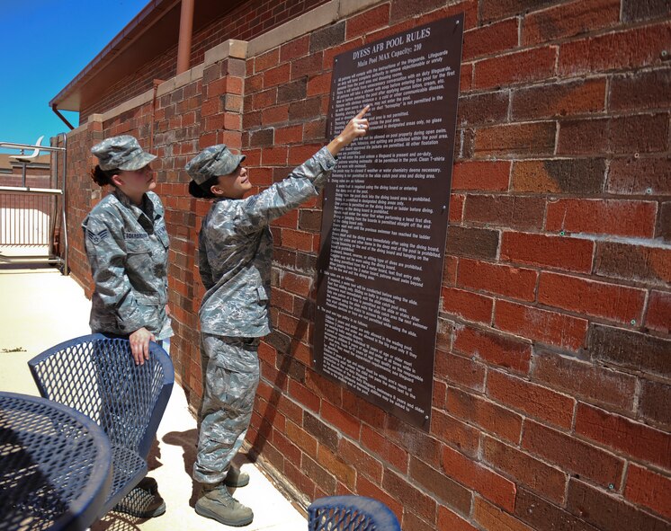 U.S. Air Force Senior Airman Morgan Scarbrough, left, and Staff Sgt. Pearla Sellar, both from the 7th Aerospace Medicine Squadron, review the pool rules to look for errors during a pre-inspection April 3, 2014, at Dyess Air Force Base, Texas. This pool inspection falls under the community health aspect of public health.  Public health personnel inspect communal places on base to improve health characteristics for patrons to safely utilize. (U.S. Air Force photo by Airman 1st Class Kedesha Pennant/Released)