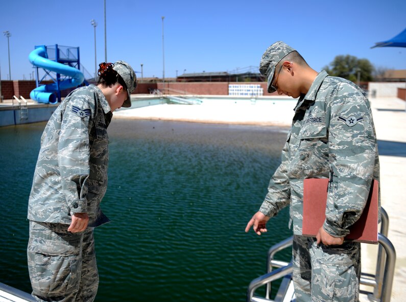 U.S. Air Force Senior Airman Morgan Scarbrough, left, and Airman Xizhe Cui, both from the 7th Aerospace Medicine Squadron, scan the Dyess outdoor pool during a pre-inspection April 3, 2014, at Dyess Air Force Base, Texas. Public health personnel are responsible for ensuring all public and food facilities on base maintain cleanliness and compliance with Food and Drug Administration regulations, keeping Team Dyess healthy and safe from disease. (U.S. Air Force photo by Airman 1st Class Kedesha Pennant/Released)