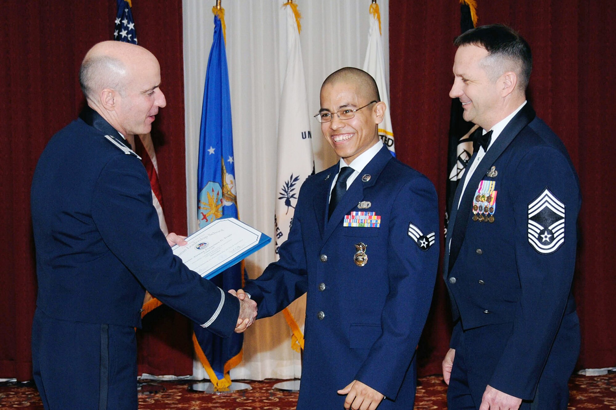 HANSCOM AIR FORCE BASE, Mass. – Senior Airman Francisco Trejo, center, is congratulated by 66th Air Base Group Commander Col. Lester A. Weilacher, left, and Chief Master Sgt. Craig A. Poling, Hanscom’s senior enlisted advisor, after being announced as the recipient of the Airman Leadership School John L. Levitow Award at the ALS graduation ceremony April 4. The Levitow award, also known as the Most Distinguished Graduate, is presented to an ALS student who achieves the highest summative objective and performance evaluations as well as instructor and peer leadership points. (U.S. Air Force photo by Linda LaBonte Britt)