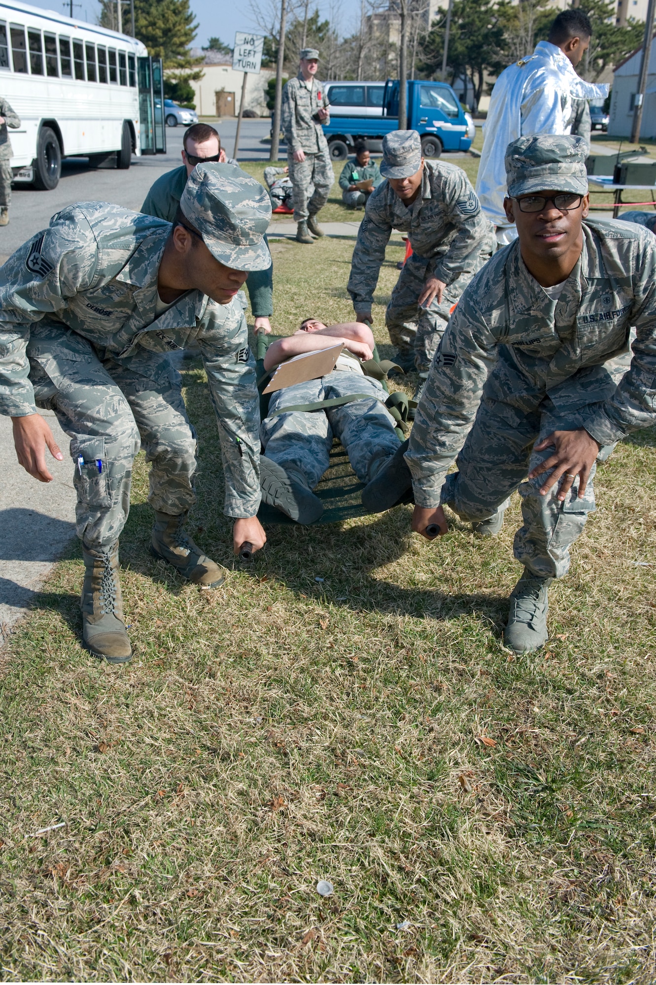 Eighth Medical Group Airmen move an injured role player to the emergency vehicle during the active shooter scenario at Kunsan Air Base, Republic of Korea, Apr. 8, 2014. Depending on how critical the injury was, injured role players were transported to either the clinic on-base. (U.S. Air Force photo by Staff Sgt. Jessica Haas/Released)