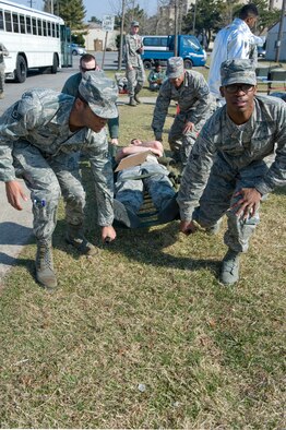 Eighth Medical Group Airmen move an injured role player to the emergency vehicle during the active shooter scenario at Kunsan Air Base, Republic of Korea, Apr. 8, 2014. Depending on how critical the injury was, injured role players were transported to either the clinic on-base or another area to simulate an off-base hospital. (U.S. Air Force photo by Staff Sgt. Jessica Haas/Released) 