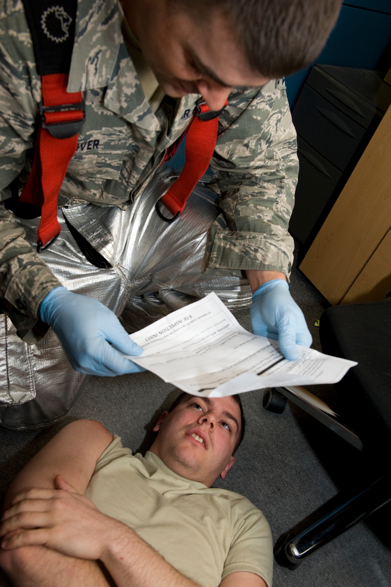 Senior Airman Larry McIver, 8th Civil Engineer Squadron firefighter, responds and treats Senior Airman Drew Zippiere, 8th Force Support Squadron force management journeyman, an injured role player during the active shooter scenario at Kunsan Air Base, Republic of Korea, Apr. 8, 2014. The area was deemed safe and clear, allowing first responders to begin aiding and moving the injured to safety. (U.S. Air Force photo by Staff Sgt. Jessica Haas/Released)
