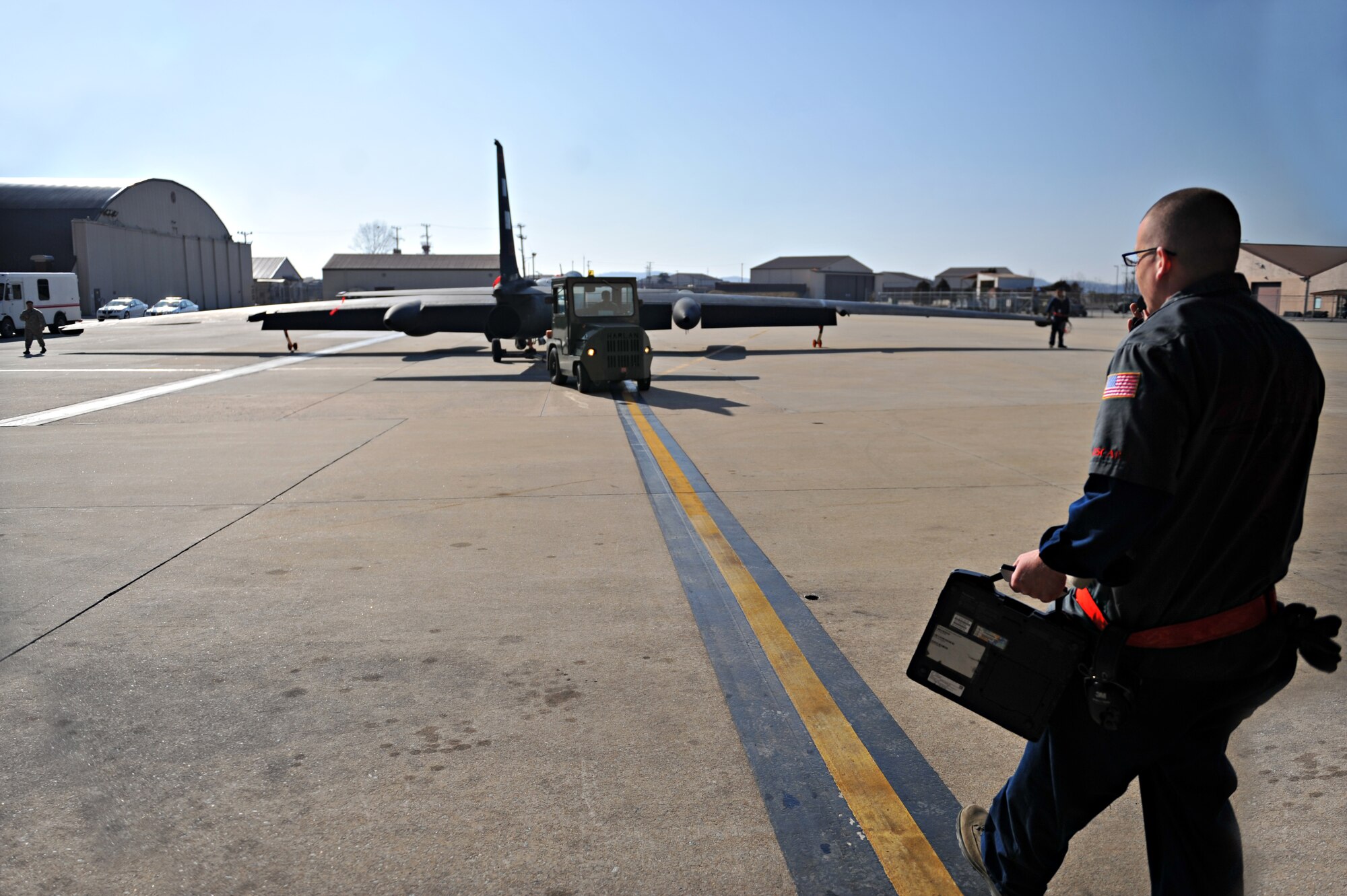 A crew chief assigned to the 5th Reconnaissance Squadron marshals a U-2 Dragon Lady into a hangar after a mission at Osan Air Base, Republic of Korea, March 10, 2014. There are members from more than 20 different Air Force Specialty Codes in the 5th RS. (U.S. Air Force photos/Senior Airman Siuta B. Ika)