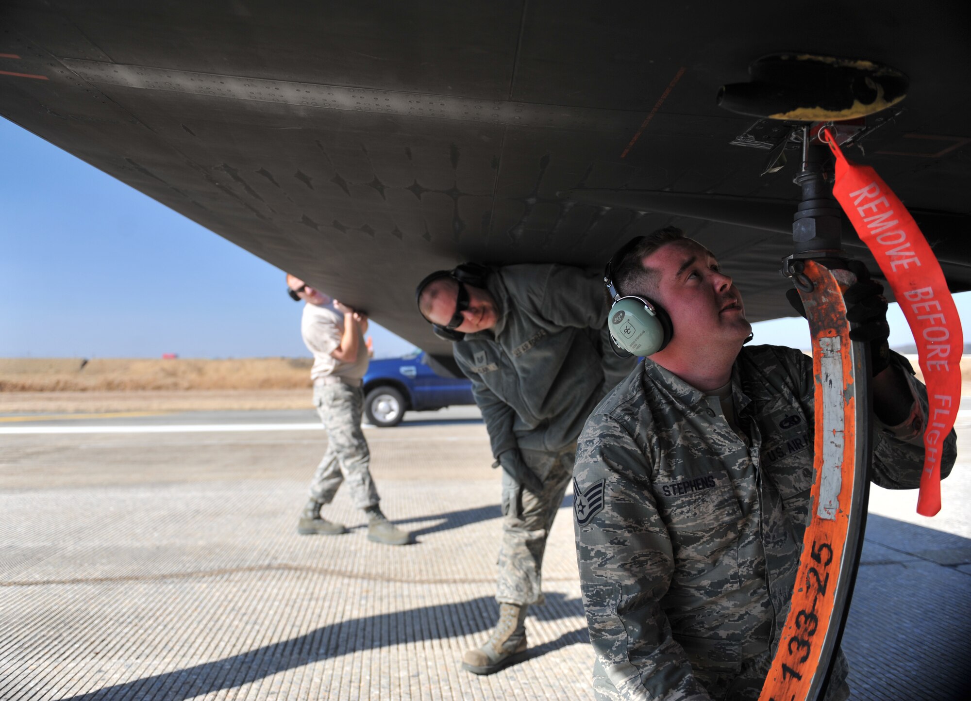 Members of the 5th Reconnaissance Squadron pogo team place a pogo under the wing of a U-2 Dragon Lady after a mission at Osan Air Base, Republic of Korea, March 10, 2014. The pogo team follows behind the U-2 during every launch and landing to clean up and install the pogos which help the U-2 maneuver easier while on the ground. (U.S. Air Force photo/Senior Airman Siuta B. Ika)