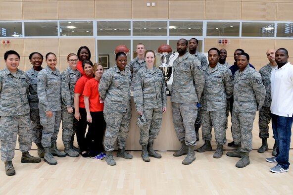 The Spangdahlem’s men and women’s basketball teams pose with their first-place trophies at the Eifel Powerhaus April 7, 2014 after competing in the 2014 United States Army Garrison European International Basketball Tournament March 21-23. The teams earned the number one spot in a total of five tournaments and a combined total of 60 games scoring more than 2,200 points. (U.S. Air Force photo by Senior Airman Alexis Siekert/Released)