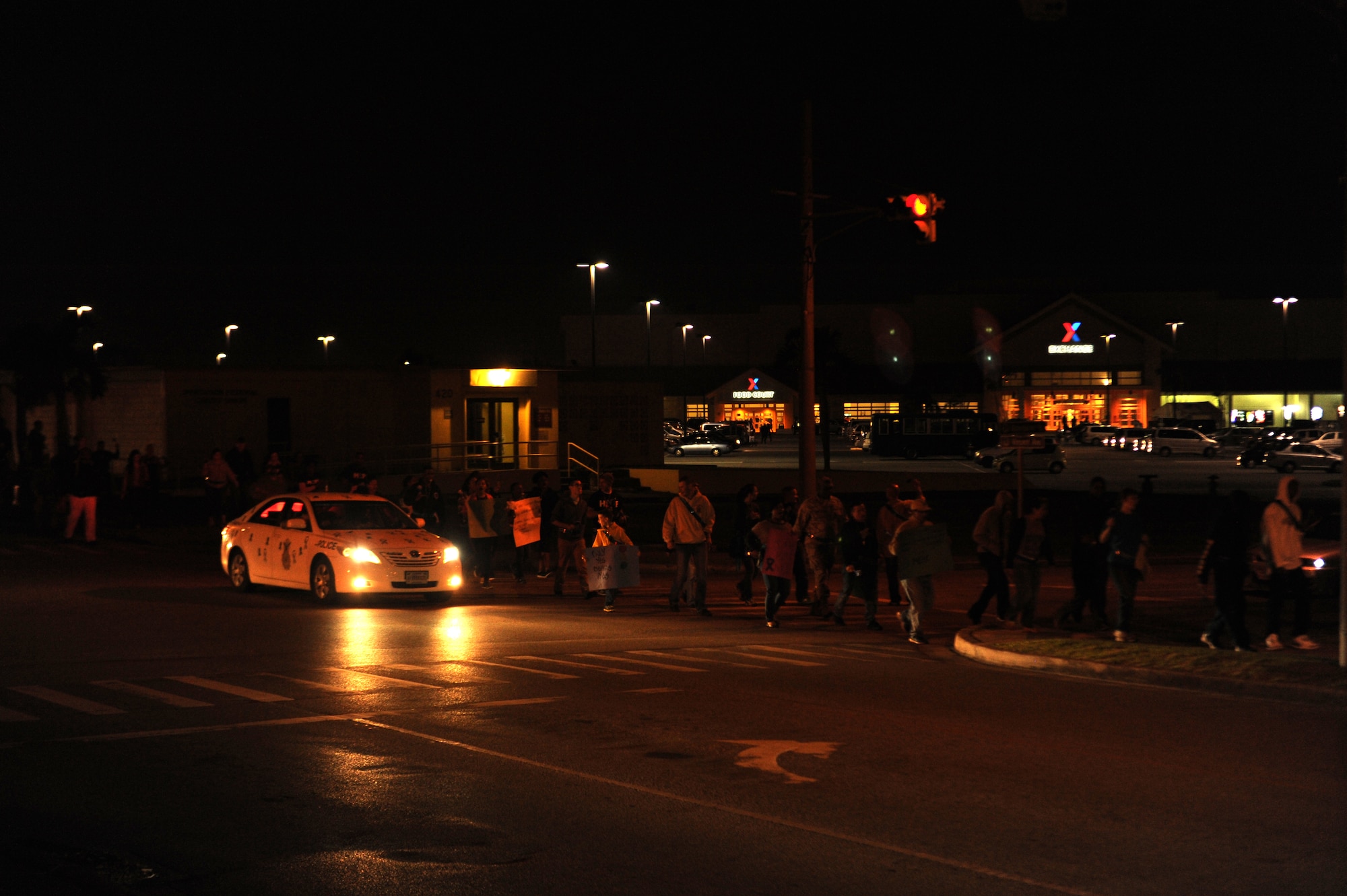 A patrol car from the 18th Security Forces Squadron sounds its siren as the Sexual Assault Prevention and Response "Take Back the Night" march ends at Chapel 2 on Kadena Air Base, Japan, April 4, 2014. Along with the 18th SFS, the Kadena Fire Department also donated a vehicle for the night, complete with sirens and flashing lights. (U.S. Air Force photo by Airman 1st Class Zackary A. Henry)
