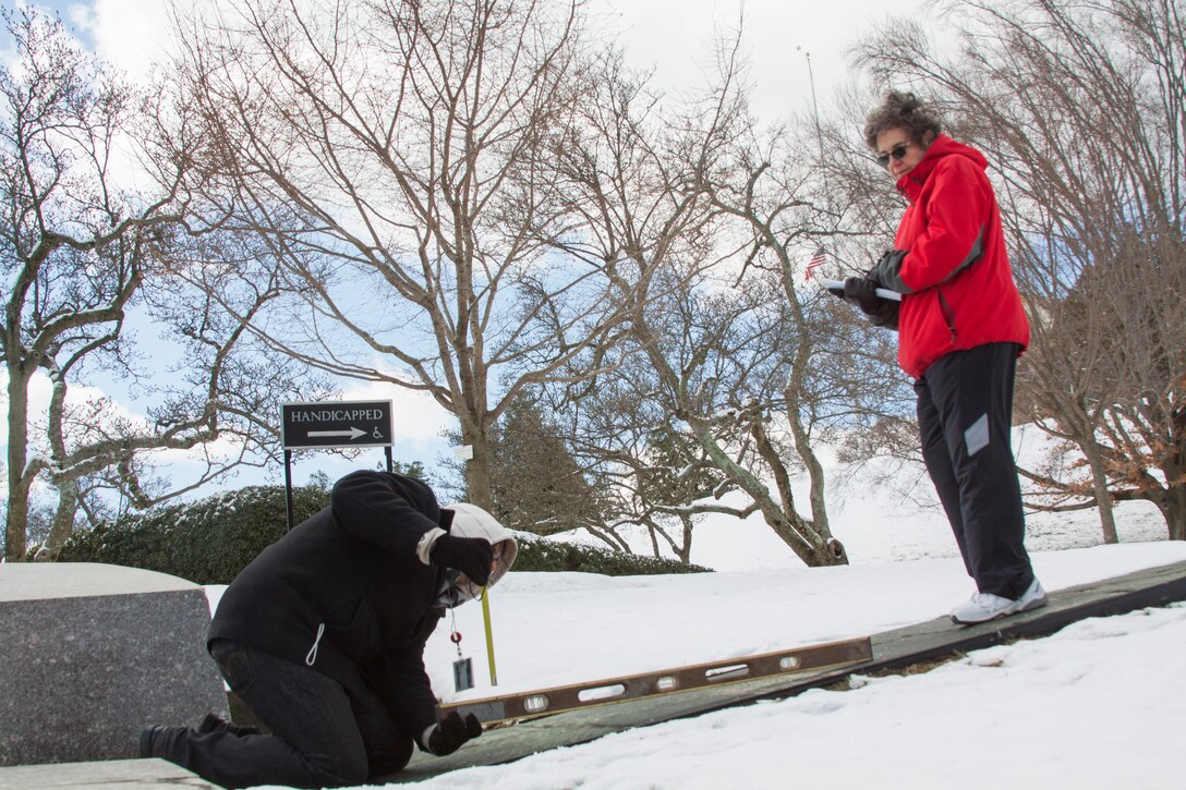 Duane Robinson, a project manager,  measures the slope of a walkway at Arlington National Cemetery while Alice Pool, a landscape architect takes notes, March 27. The two Norfolk District employees are a part of a district team assisting the cemetery with a study that will determine where it can improve the visitor experience for guests who are disabled.  (U.S. Army photo/Patrick Bloodgood)