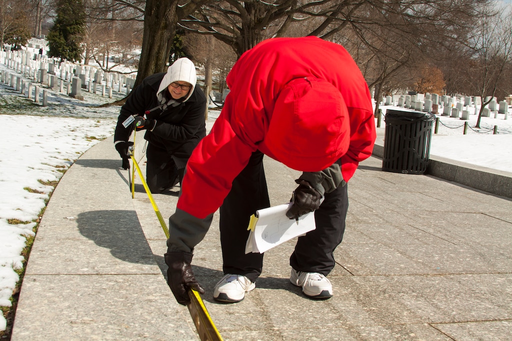 Alice Pool, a landscape architect, assists Duane Robinson, a project manager, measure the slope of a walkway at Arlington National Cemetery on March 27. The two Norfolk District employees are a part of a district team assisting the cemetery with a study that will determine where it can improve the visitor experience for guests who are disabled.  (U.S. Army photo/Patrick Bloodgood)