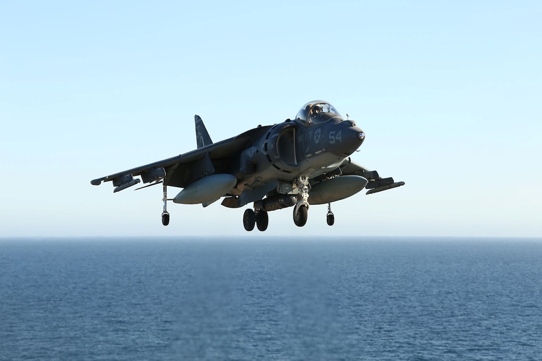 An AV-8B Harrier with Marine Medium Tiltrotor Squadron 163 (Reinforced), 11th Marine Expeditionary Unit, flies above the USS Makin Island during Amphibious Squadron Marine Expeditionary Unit Integration Training (PMINT) off the coast of San Diego, Calif., April 7, 2014.  PMINT is a two-week predeployment training event focused on the combined capabilities of the MEU and Amphibious Ready Group (ARG), conducting amphibious operations, crisis response and limited contingency operations.  (U.S. Marine Corps photo by Lance Cpl. Laura Y Raga/Released)