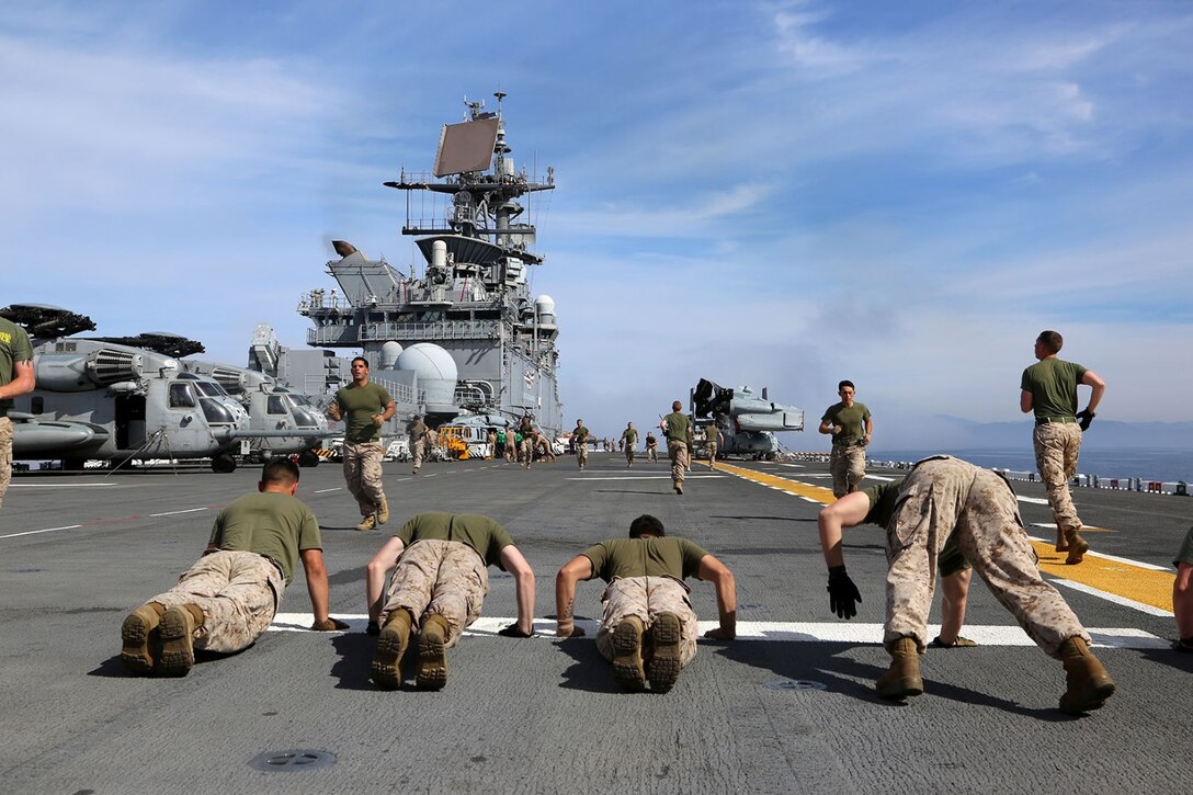 Marines with Golf Company, Battalion Landing Team 2nd Battalion, 1st Marines, 11th Marine Expeditionary Unit, conduct daily morning section physical training on the flight deck of the USS Makin Island during Amphibious Squadron Marine Expeditionary Unit Integration (PMINT), off the coast of San Diego, Calif., April 9, 2014.  PMINT is a two-week long pre-deployment training event focusing on the combined capabilities of the Marine Expeditionary Unit and Amphibious Ready Group (ARG), conducting amphibious operations, crisis response and limited contingency operations.  (U.S. Marine Corps photo by Gunnery Sgt. Rome M. Lazarus/Released)
