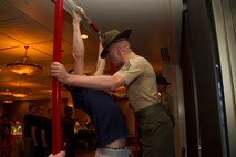 Staff Sgt. Robert M. Surozenski, a Drill Instructor from Marine Corps Recruit Depot San Diego, motivates a poolee during a partial Initial Strength Test at Recruiting Substation La Crosse’s Family Night pool function, Mar. 31.  Family Nights give poolees their first glimpse into Marine Corps recruit training and allow family members to voice any questions or concerns they may have about recruit training.