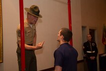 Staff Sgt. Robert M. Surozenski, a Drill Instructor from Marine Corps Recruit Depot San Diego, instructs a poolee to mount the pull-up bar during a partial Initial Strength Test at Recruiting Station Milwaukee’s Family Nights pool function, Apr. 5.  Family Nights give poolees their first glimpse into Marine Corps recruit training and allow family members to voice any questions or concerns they may have about recruit training.