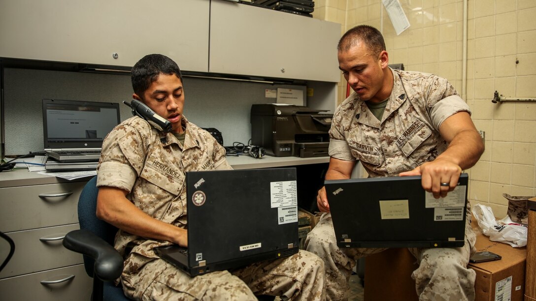 Sergeant Spencer C. Garvin, right, works with Sgt. Richard Hernandez, both cyber network operator with the 15th Marine Expeditionary Unit, to resolve issues on laptops aboard Camp Pendleton, Calif., April 7, 2014. Garvin, 26, is from Elko, Nev. (U.S. Marine Corps photo by Cpl. Emmanuel Ramos/Released)