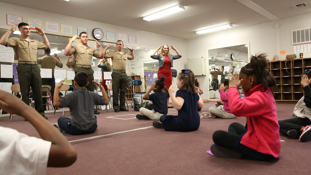 Students learn how to tell a pilot to close an aircraft’s wings at Oaks Road Elementary School in New Bern, N.C.,  April 4, 2014. Marines volunteered through Marine Corps Air Station Cherry Point’s Single Marine Program to participate in the school’s career day. 