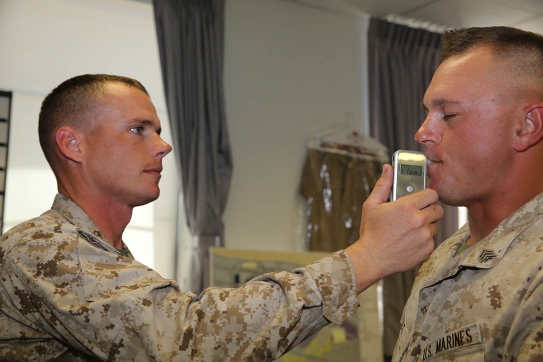 Staff Sgt. Jeffery Worley, substance abuse control officer on Marine Corps Logistics Base Barstow, Calif., administers a
breathalyzer test to Sgt. Darren Cole, October 24, 2013. The Marine Corps administers random breathalyzer tests in addition
to urinalysis tests to help prevent substance abuse within the Corps.