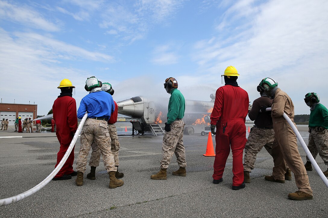 Sailors from the Center for Naval Aviation Technical Training Unit, Lemoore Calf., in red, train Marines with Marine Attack Squadron 542 on shipboard firefighting at Marine Corps Air Station Cherry Point, N.C., April 3, 2014. The Marines were learning the basics of shipboard firefighting in preparation for their upcoming deployment with the 31st Marine Expeditionary Unit.