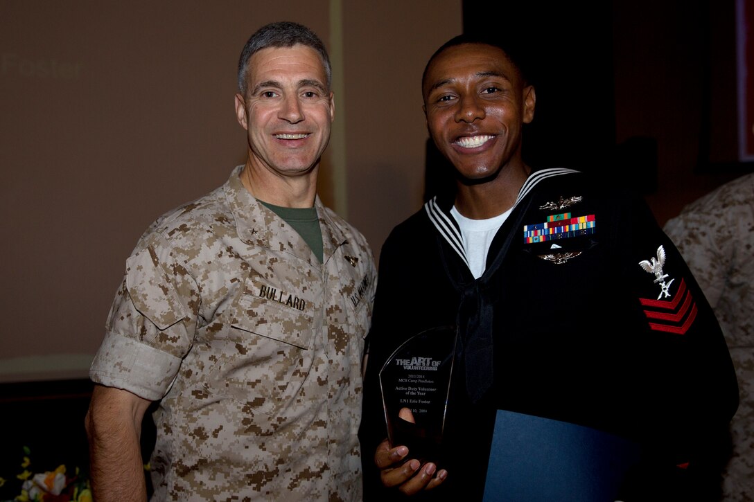Petty Officer 1st Class Eric Foster, recipient of the Active Duty Volunteer of the Year award, poses with Brig. Gen. John W. Bullard, commanding general of Marine Corps Installations-West, during the 2014 Volunteer Recognition Ceremony at the Pacific Views Event Center April 10. More than 6,000 military and civilian volunteers from several units on Camp Pendleton accumulated a total of 110,461 hours of volunteer service in 2013. 