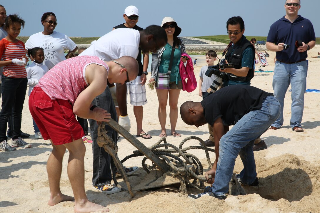 Marine volunteers unearth a buried anchor April 5 during the third annual Ginowan Tropical Beach Cleanup at Tropical Beach in Ginowan City, Okinawa. Community and service members worked together to clean the beach of waste and debris. The Marines are with Marine Aviation Logistics Squadron 36, Marine Aircraft Group 36, 1st Marine Aircraft Wing, III Marine Expeditionary Force.