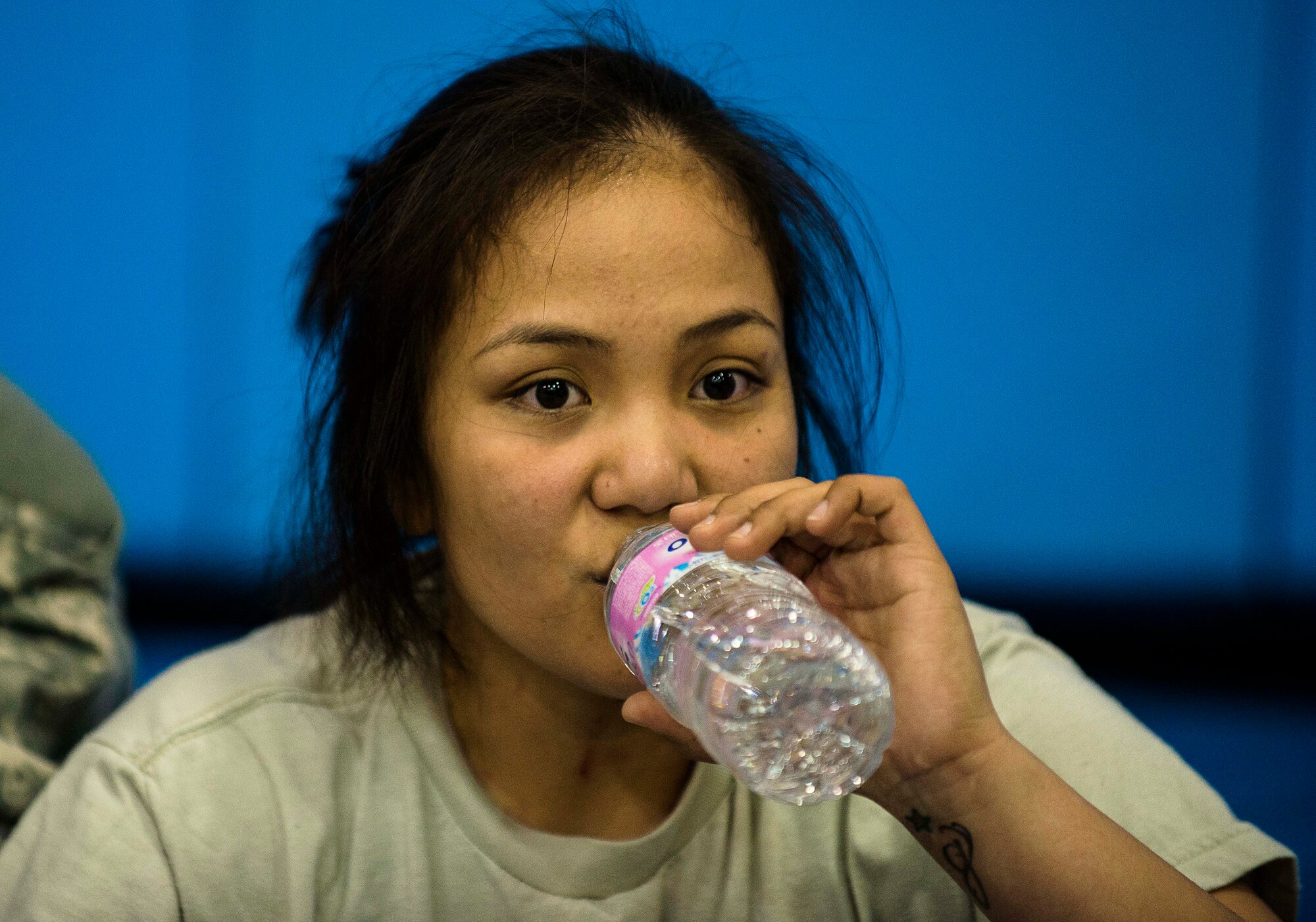 A soldier drinks water after her combatatives fight March 19, 2014, at Osan Air Base, Republic of Korea. The tournament fighting classes are determined by weight and feature intergender matchups. (U.S. Air Force photo by Staff Sgt. Jake Barreiro)