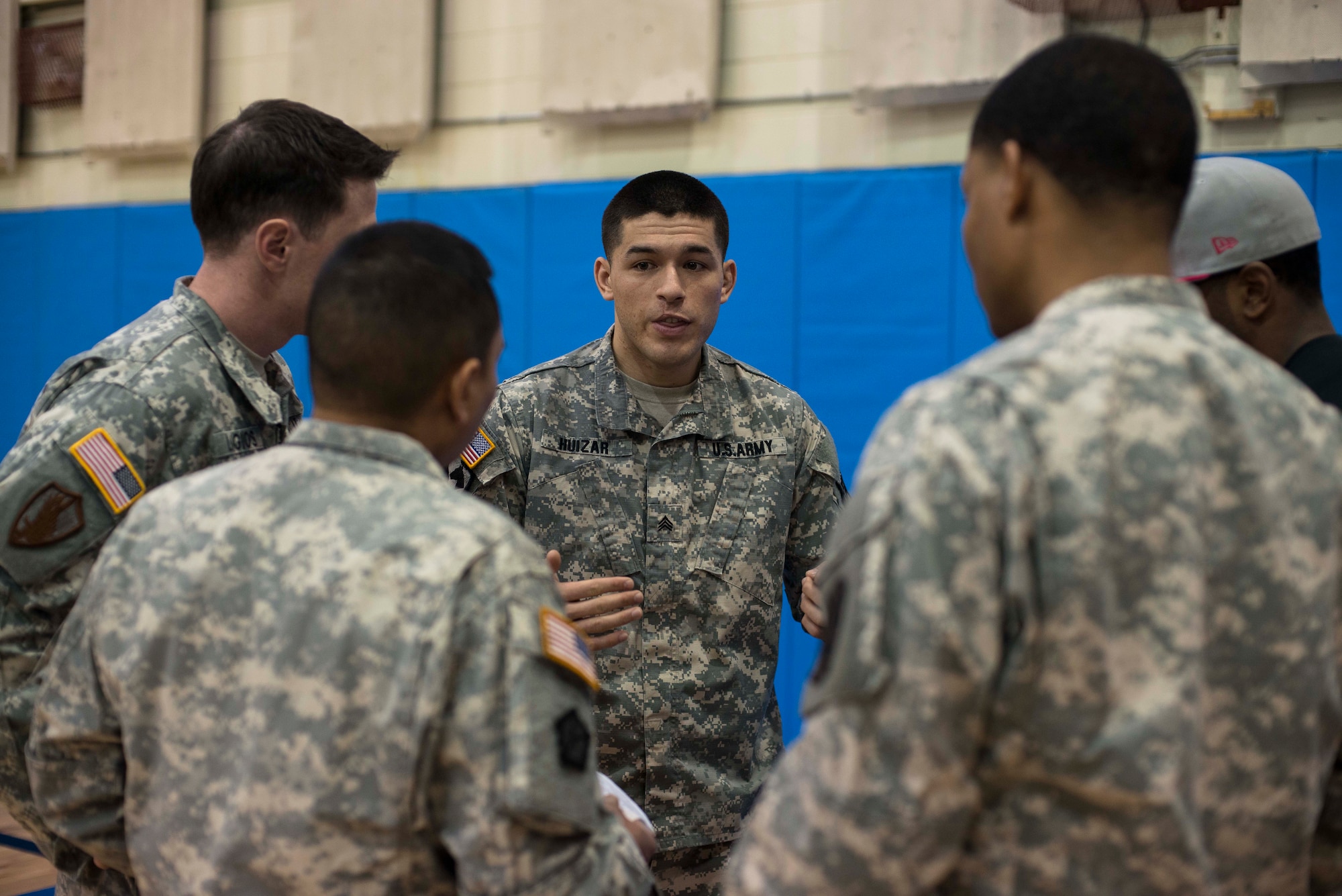 Referees confer before the start of an Army combatatives tournament March 19, 2014, at Osan Air Base, Republic of Korea. The Army combatatives program involves routine training and fighting to achieve specific skill levels. (U.S. Air Force photo by Staff Sgt. Jake Barreiro)