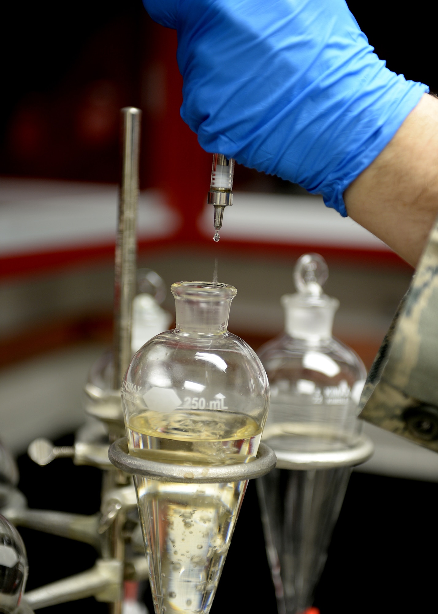 Senior Airman David Anastasio, 354th Logistic Readiness Squadron fuels lab technician, adds testing solvents to a separating funnel April 10, 2014, Eielson Air Force Base, Alaska. The test shows the effectiveness of solvents separating water from the fuel. (U.S. Air Force photo by Staff Sgt. Shawn Nickel/Released)