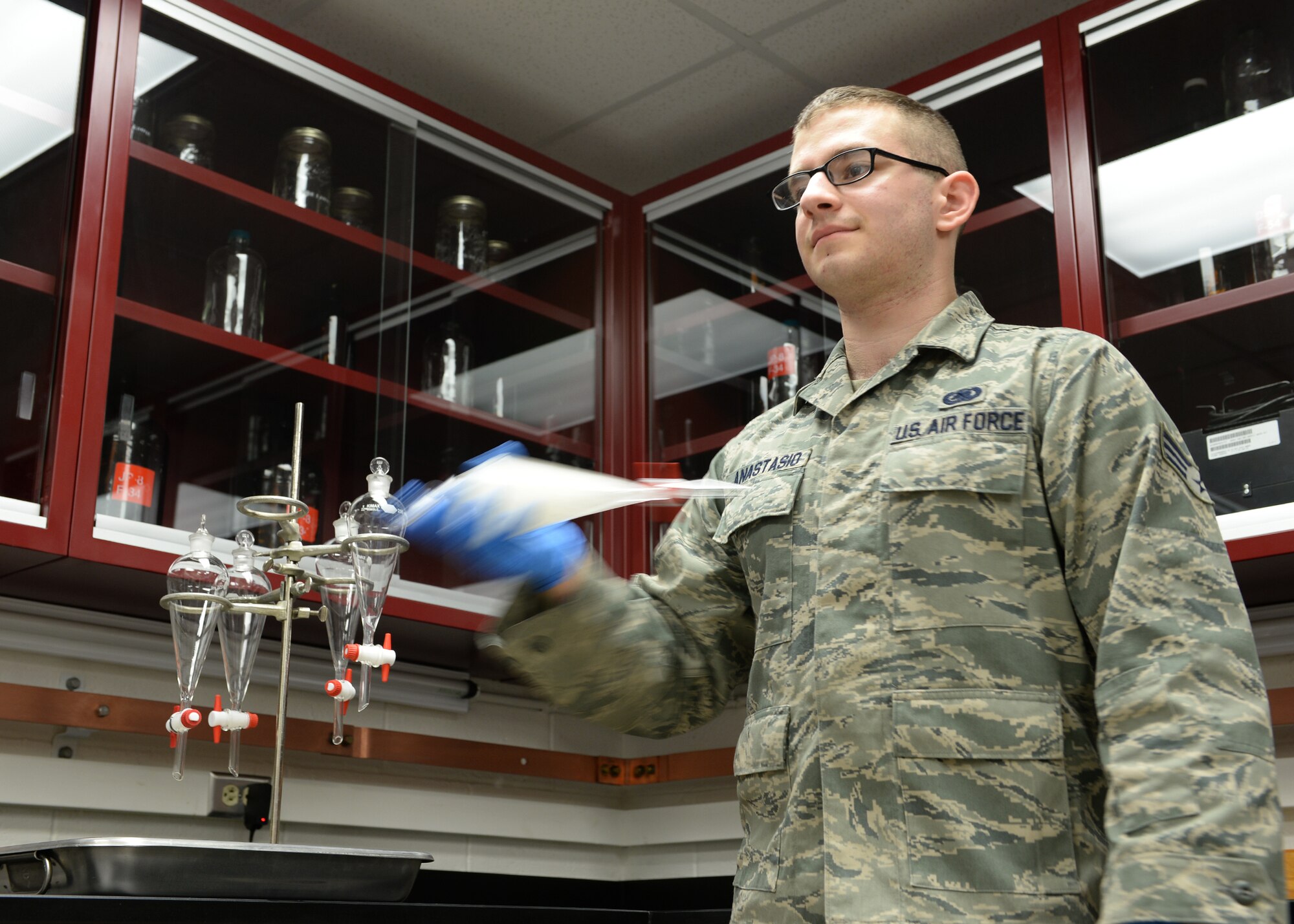 Senior Airman David Anastasio, 354th Logistic Readiness Squadron fuels lab technician, shakes a fuel sample in a separating funnel after applying testing solvents April 10, 2014, Eielson Air Force Base, Alaska. The test shows the effectiveness of solvents separating water from the fuel. (U.S. Air Force photo by Staff Sgt. Shawn Nickel/Released)