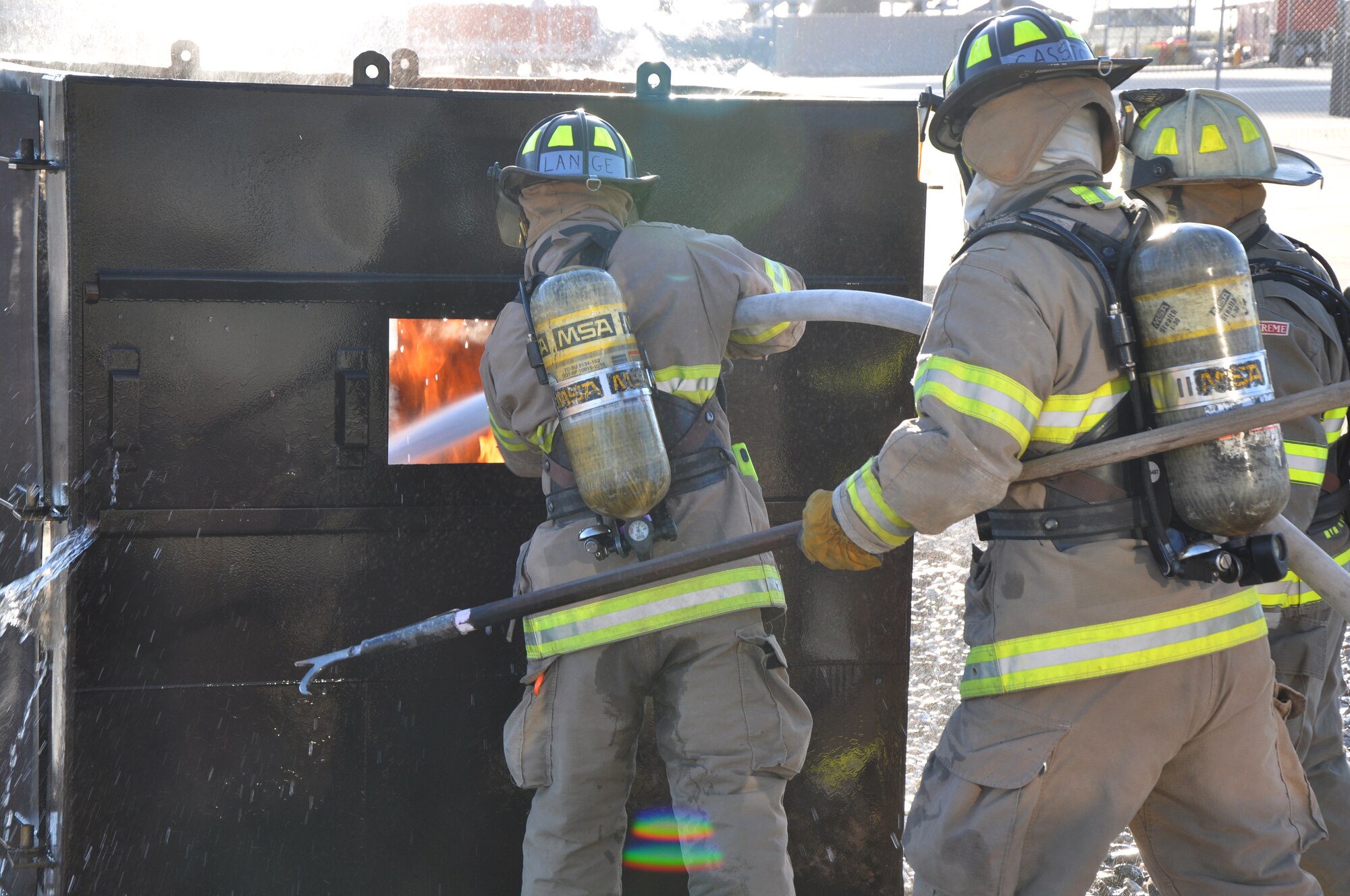 GOODFELLOW AIR FORCE BASE, Texas - Jaden W. Lange, San Angelo Fire Department recruit, sprays water into a dumpster fire at the Louis F. Garland Department of Defense Fire Academy here April 9. While Lange fought the fire, Steven L. Gassiot, SAFD recruit, assisted him by helping brace the hose or by using the hook to open the doors to the dumpster. (U.S. Air Force photo/ Senior Airman Joshua Edwards)