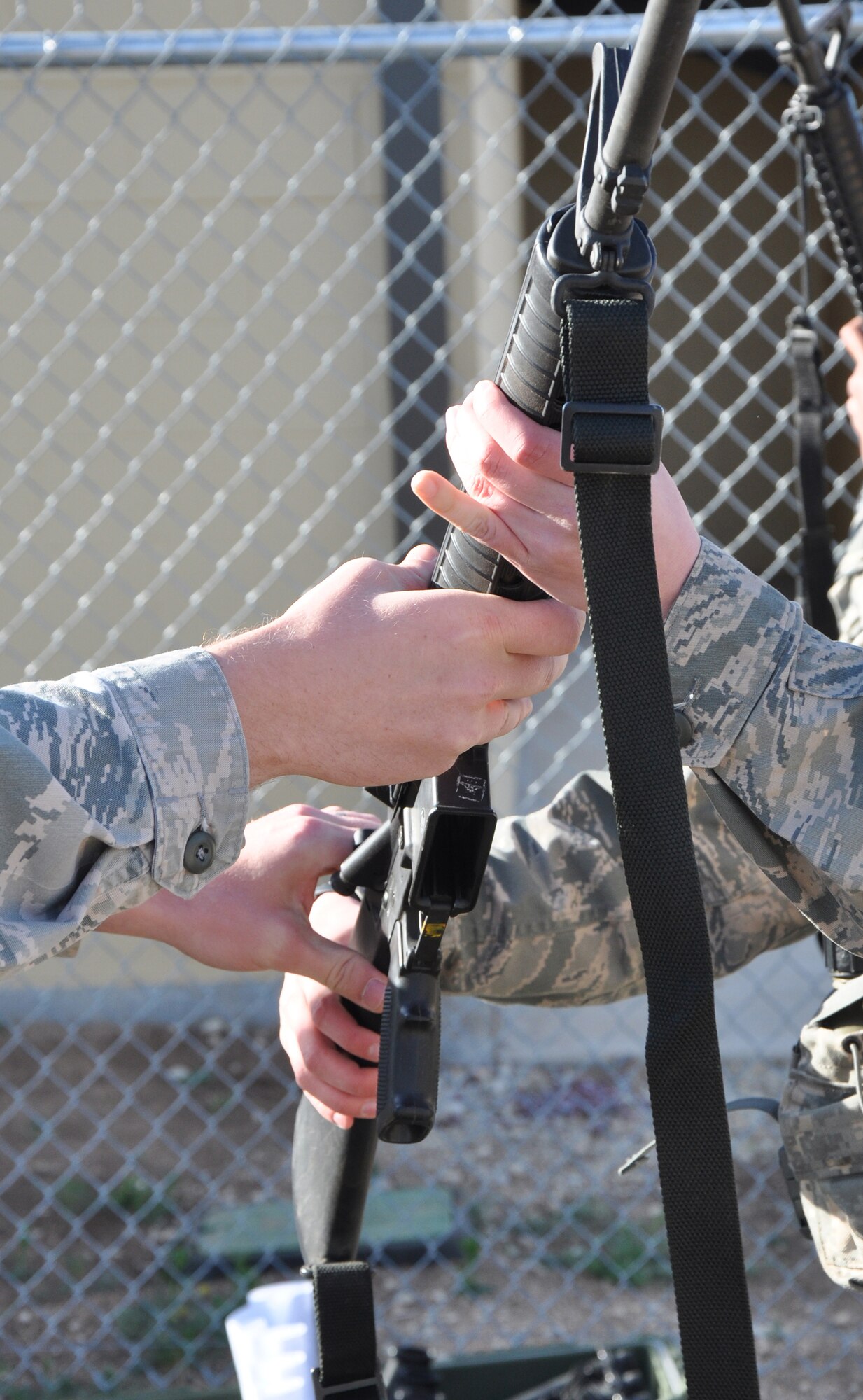GOODFELLOW AIR FORCE BASE, Texas –A 17th Security Forces Squadron staff sergeant hands an Angelo State University Air Force ROTC Detachment 847 cadet her weapon for a field training exercise at Camp Sentinel here April 4. All the participating cadets received their own weapon, and the 17th SFS taught them about muzzle control and ammo conservation. (U.S. Air Force photo/ Senior Airman Joshua Edwards)